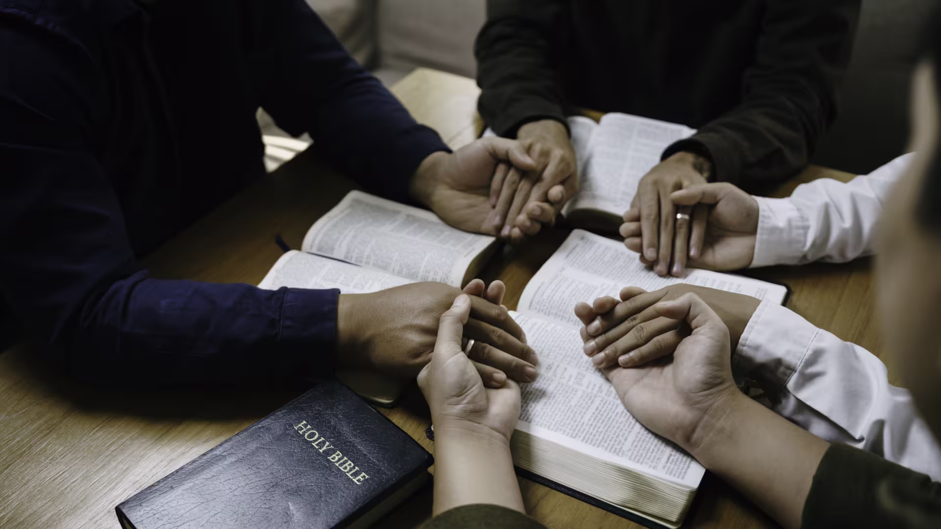 Missionaries hold hands during prayer