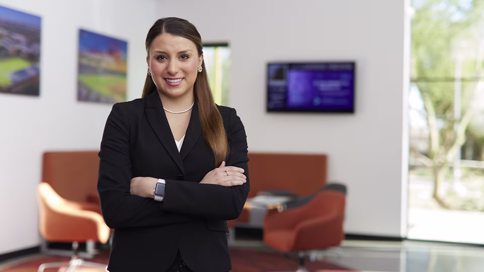 Female business student has arms folded and smiling at camera