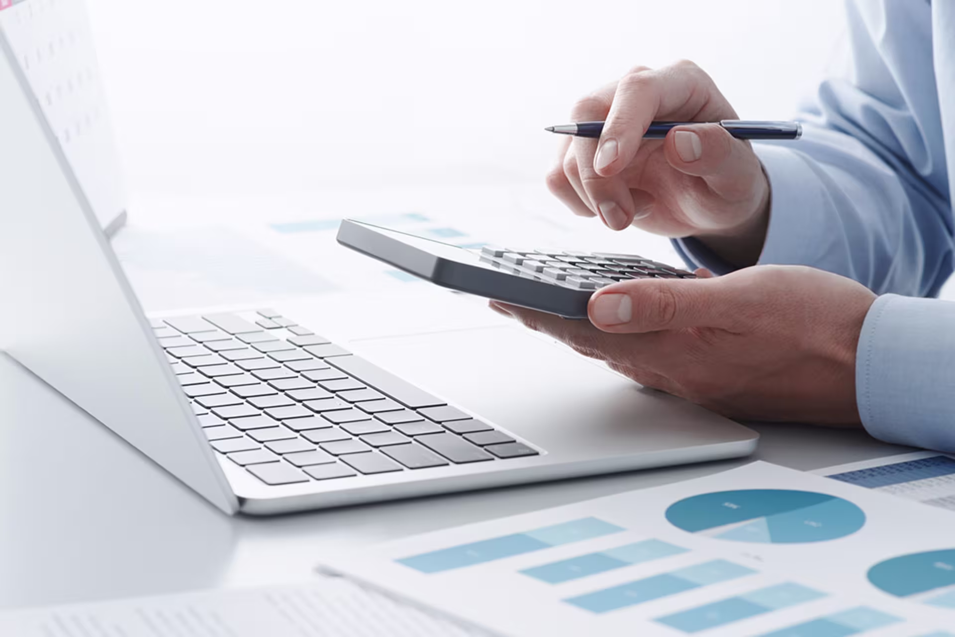 Male accounting student studying on laptop and also using calculator