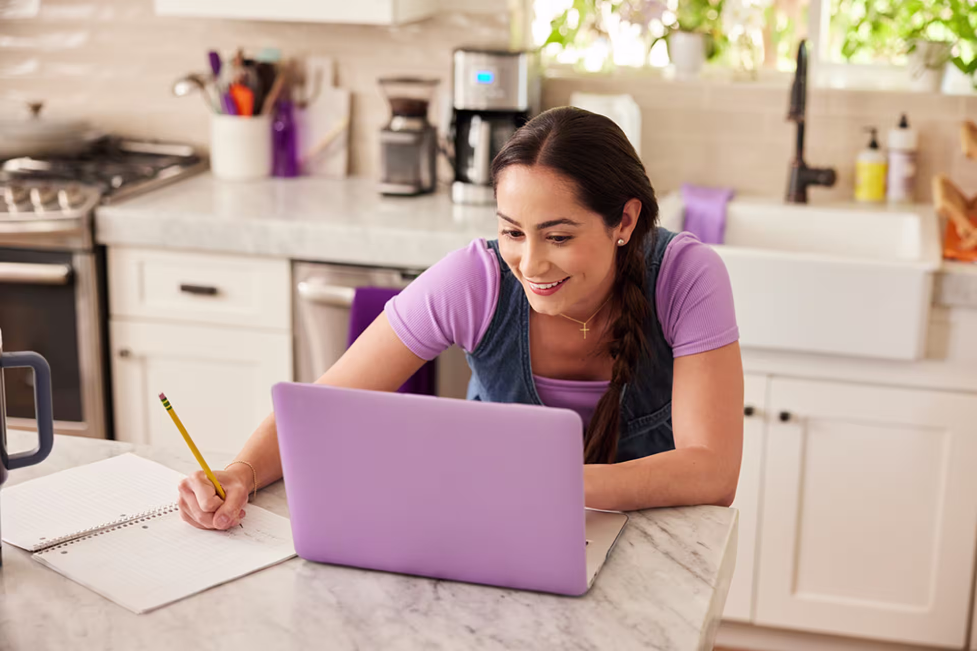 Female student studying on laptop in her kitchen