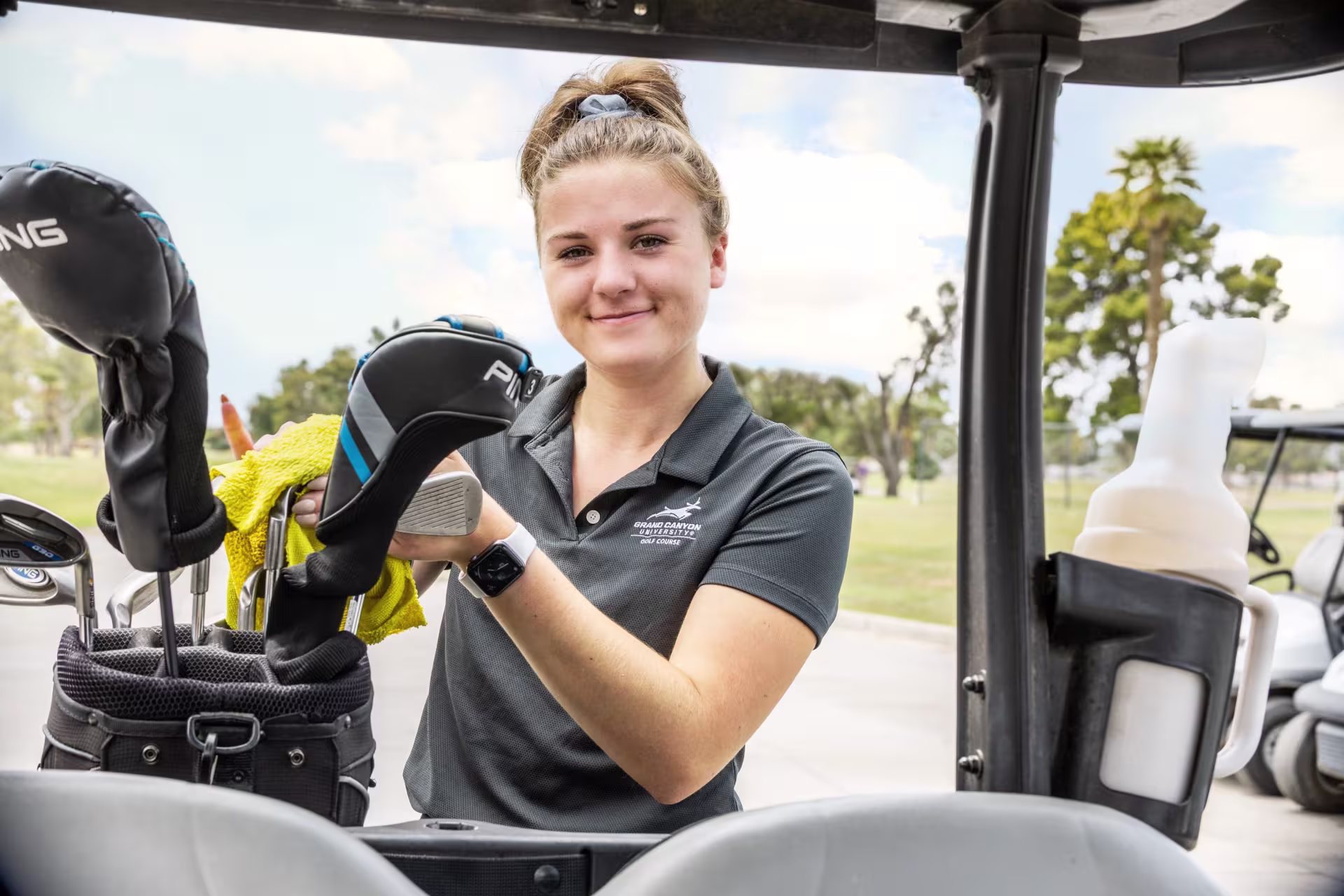 Hospitality student loading golf clubs