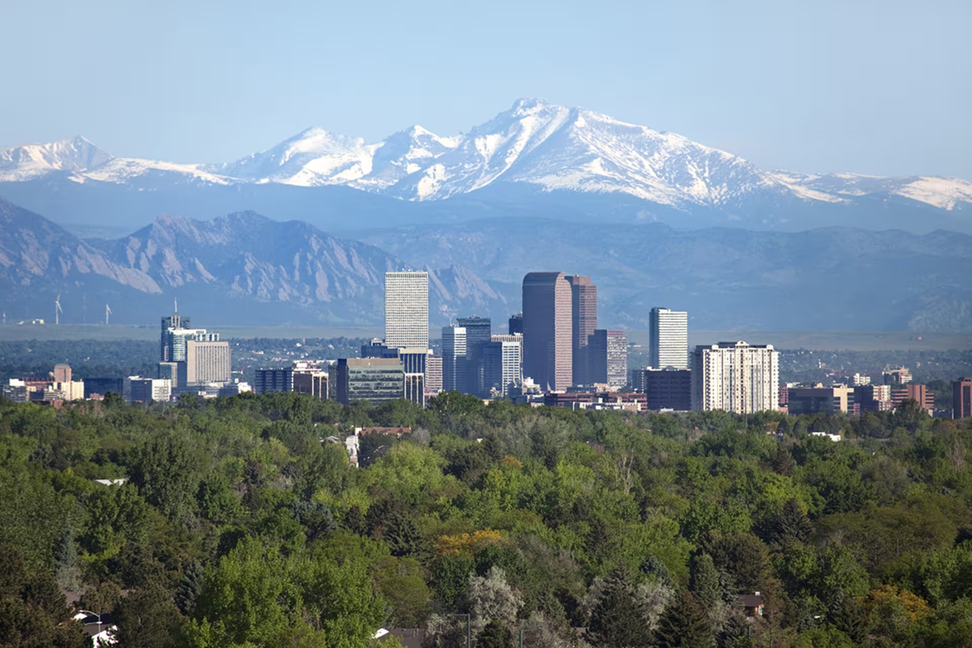 downtown Denver skyscrape with snow capped rocky mountains in far off distance