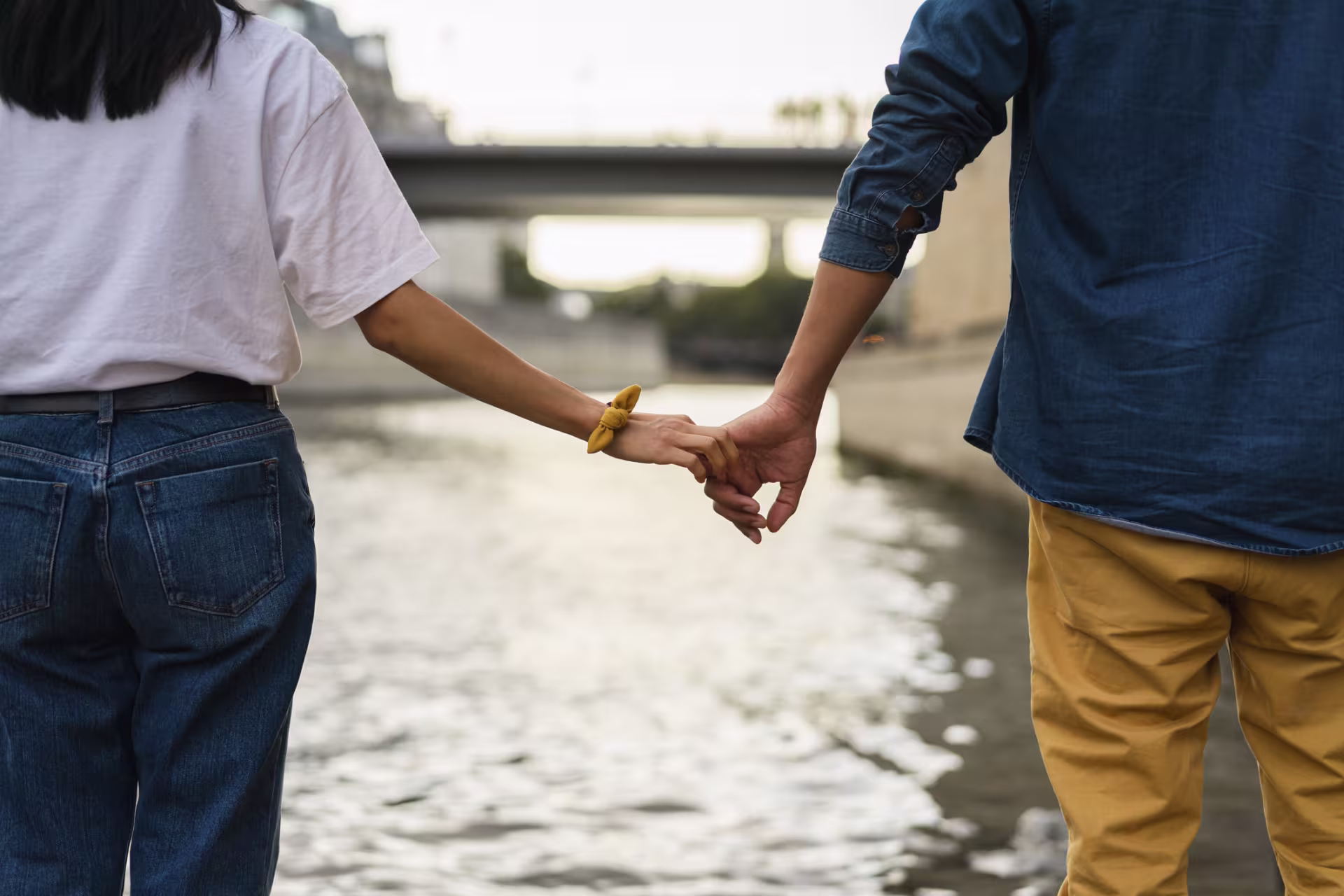 Couple holding hands by river