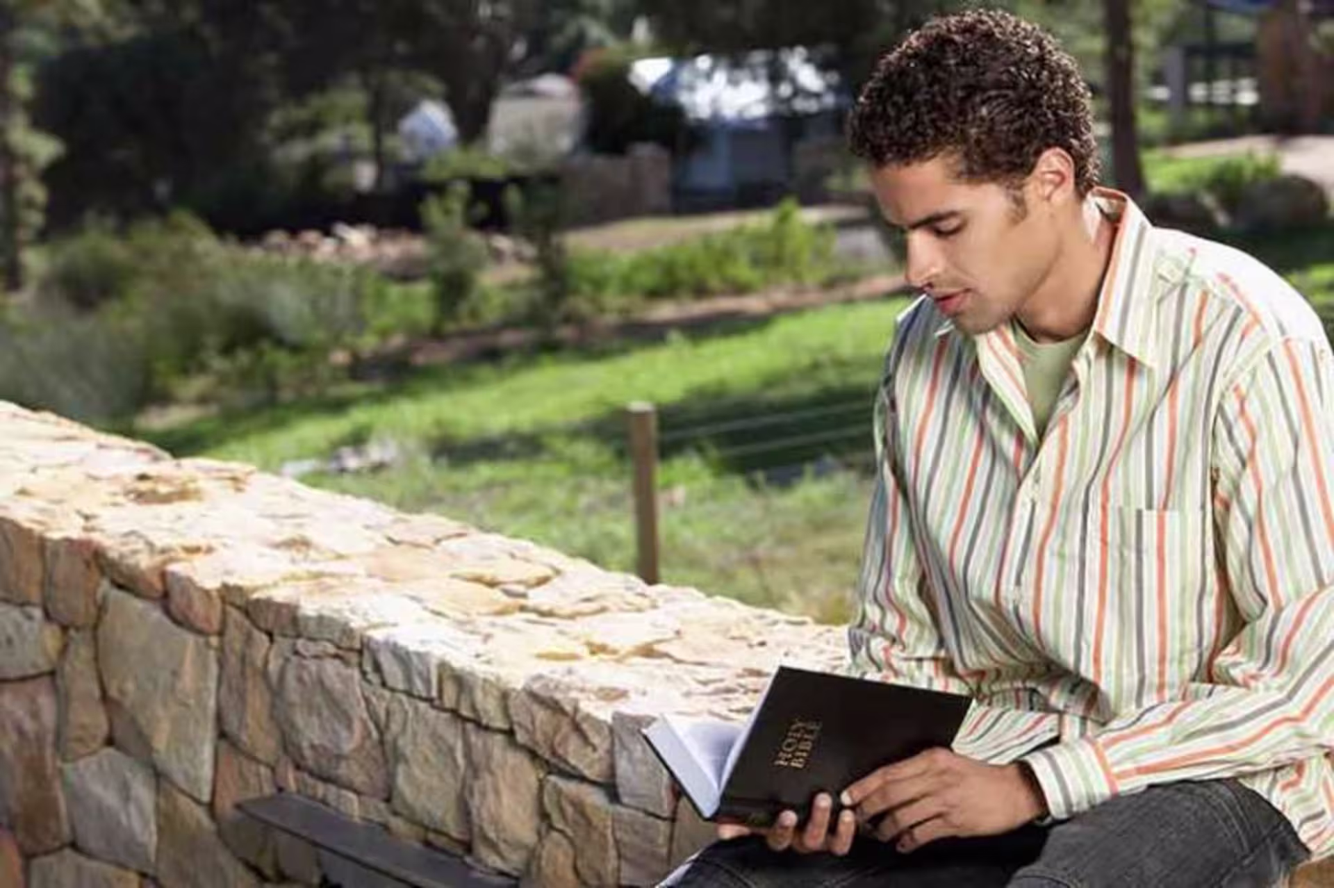 Man sitting while reading the Bible