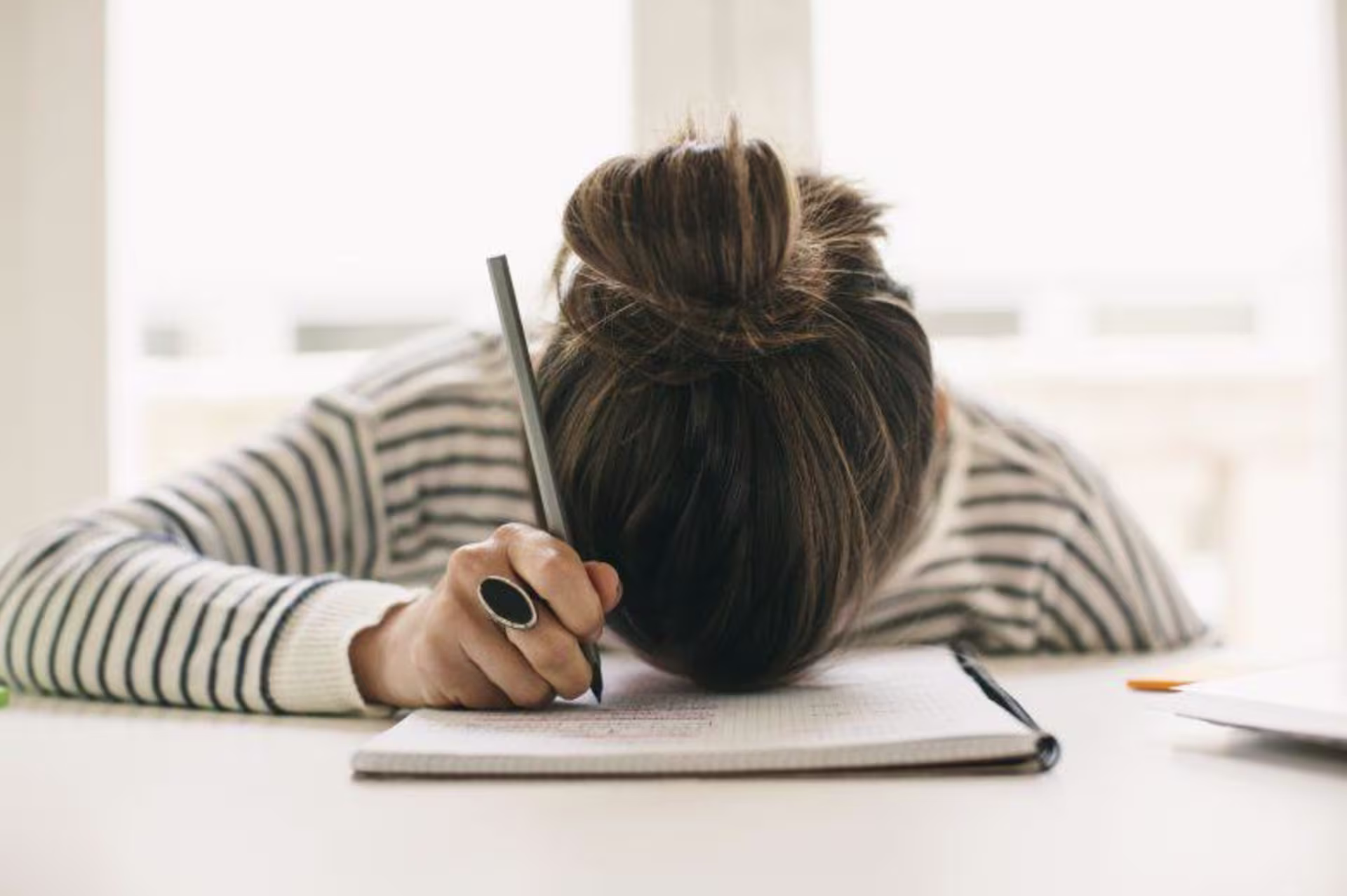 Overwhelmed student with her head on her desk