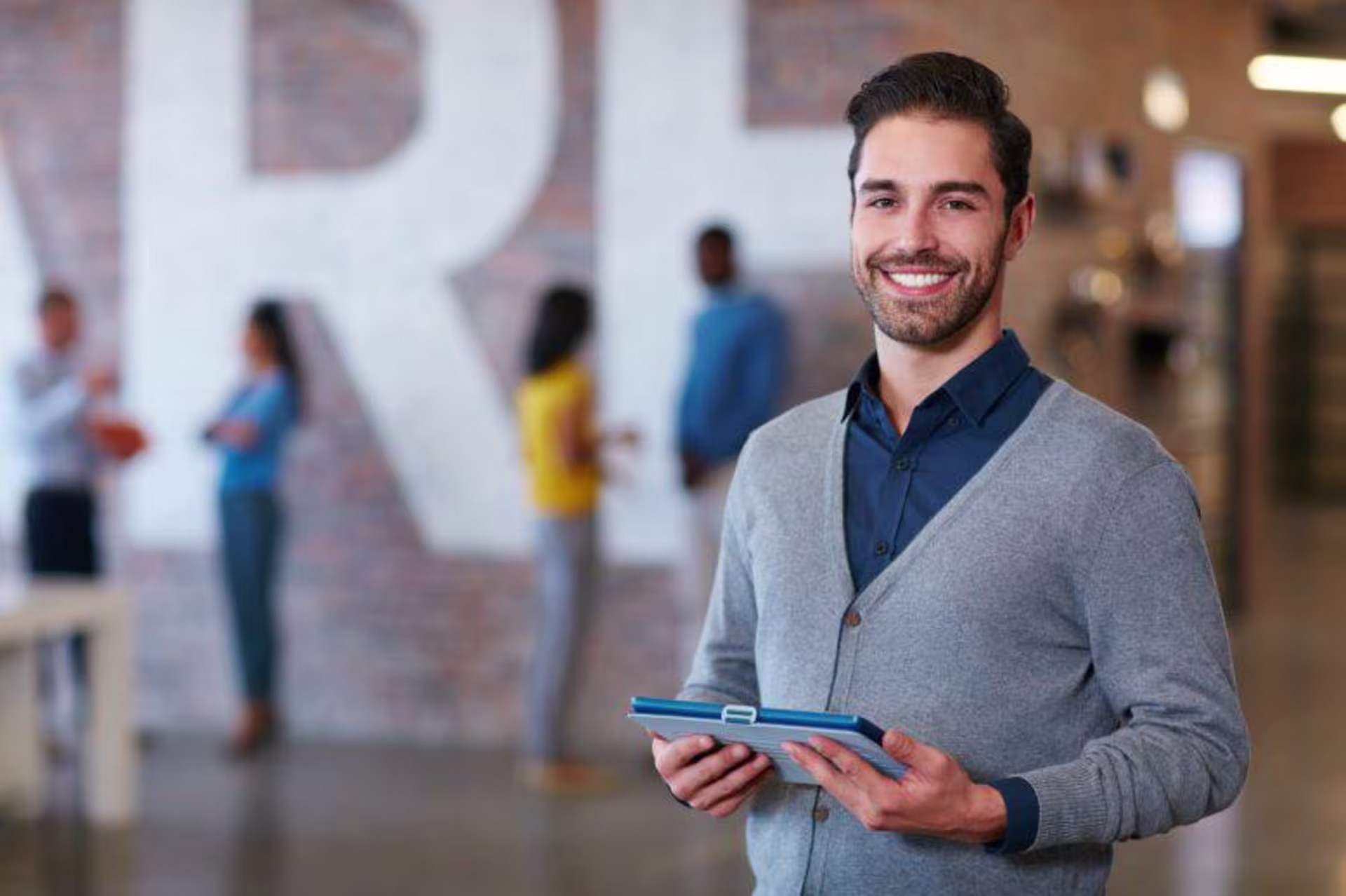 A professionally-dressed man holding a binder