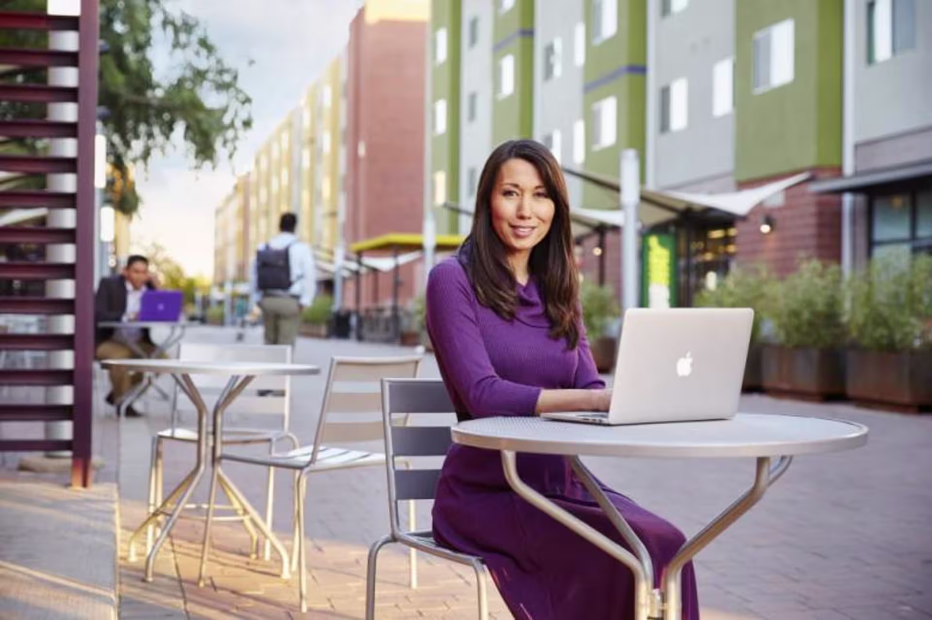Female doctoral student working on a laptop at an outdoor table