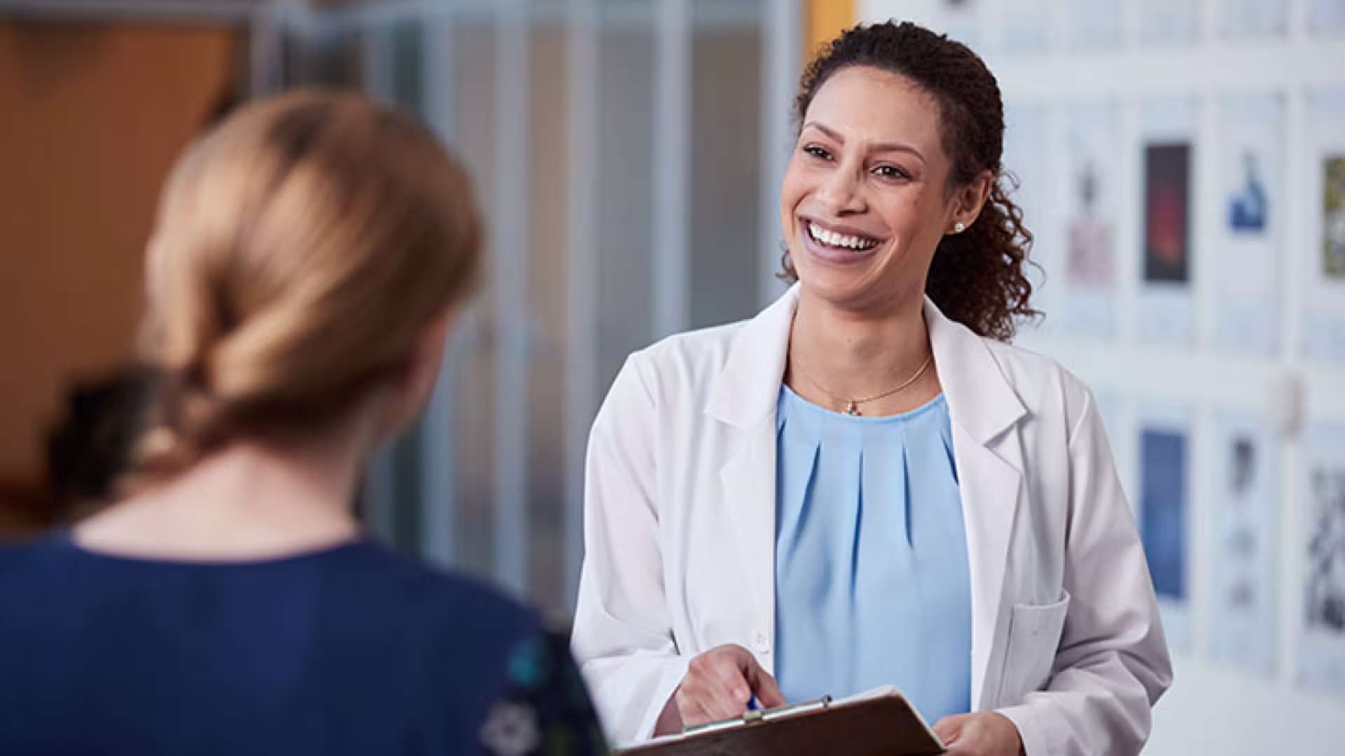 Women's Health Administrator discusses with a patient in clinical setting