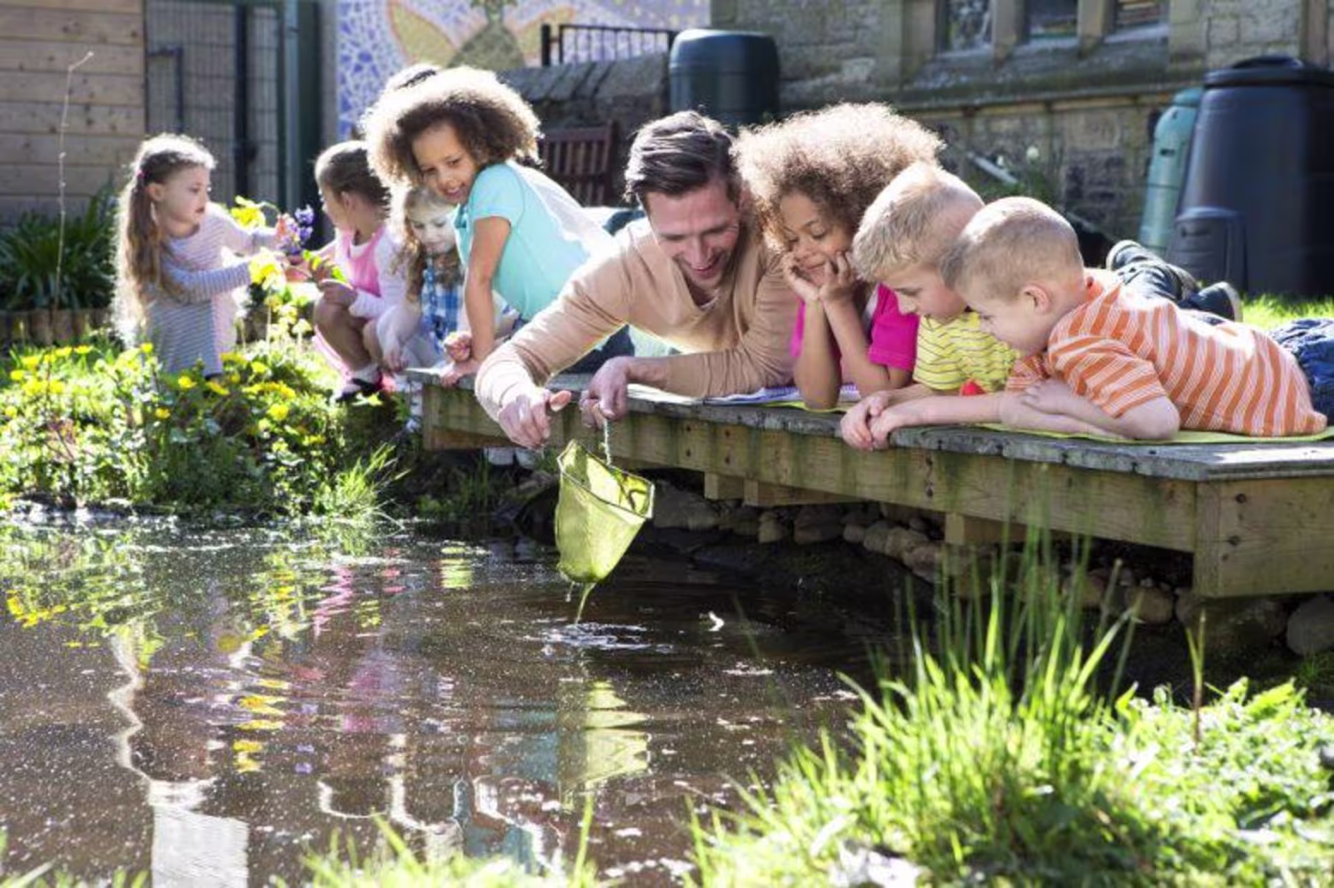 students and teacher outside looking at a pond