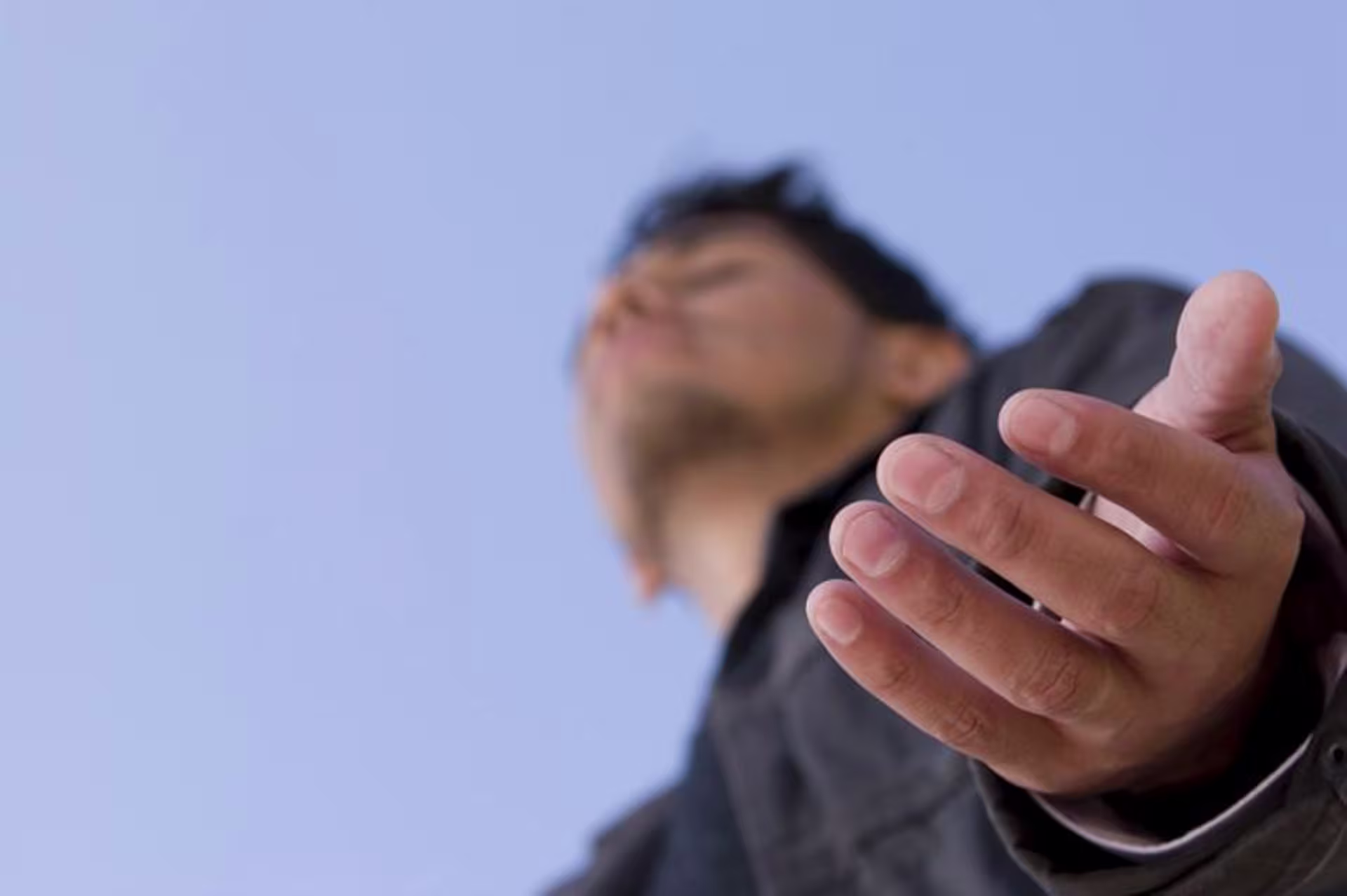 Man holds his hands out with eyes closed to receive God's Blessing