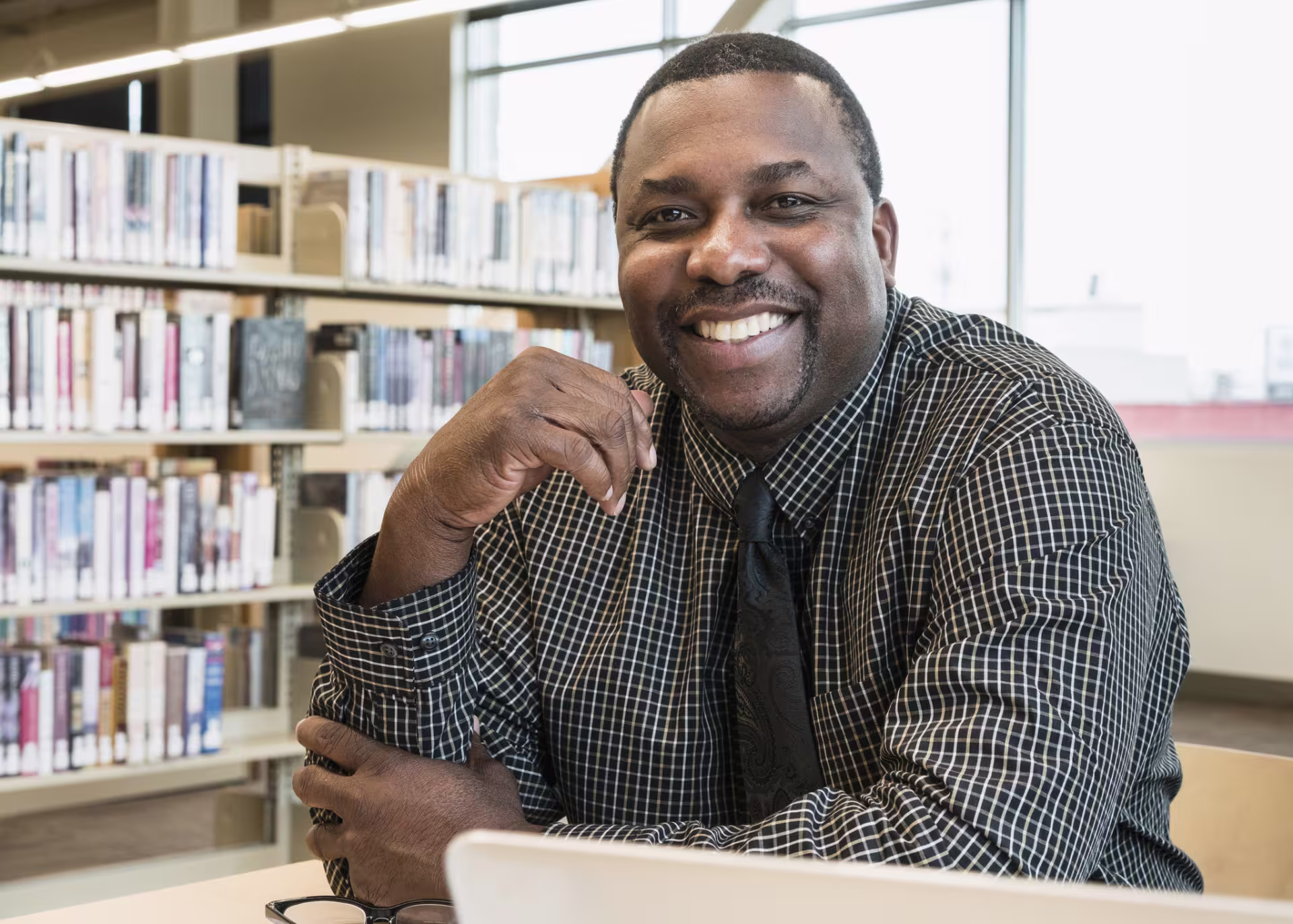 Principal smiles in school library.