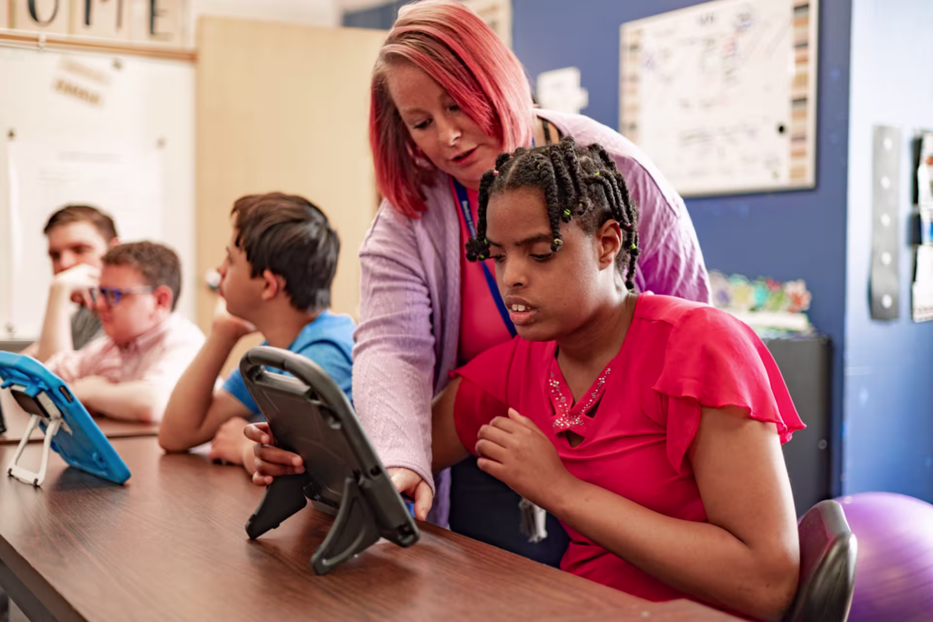 Special education teacher works with young student.