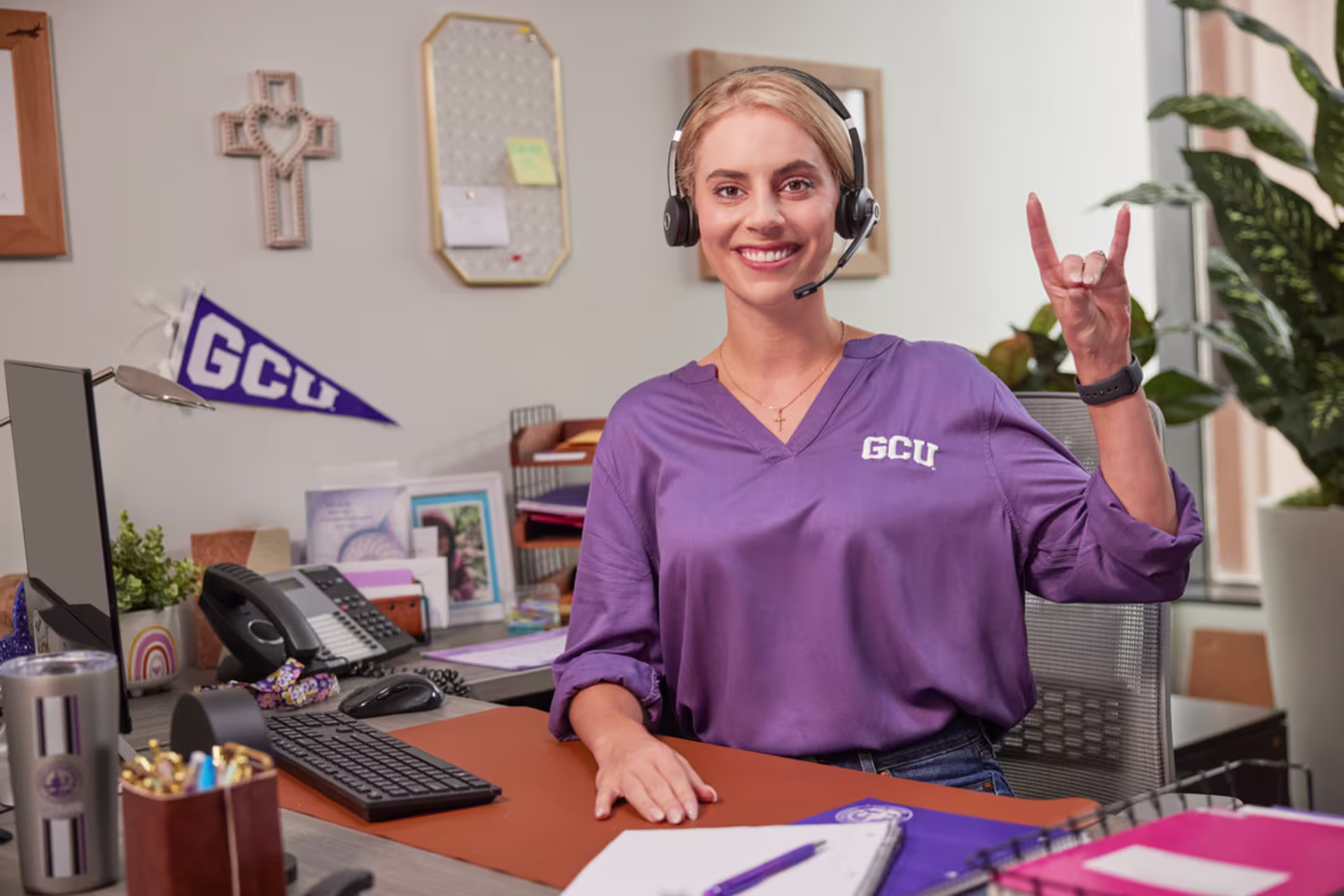 Female college admissions counselor smiling at desk in office.