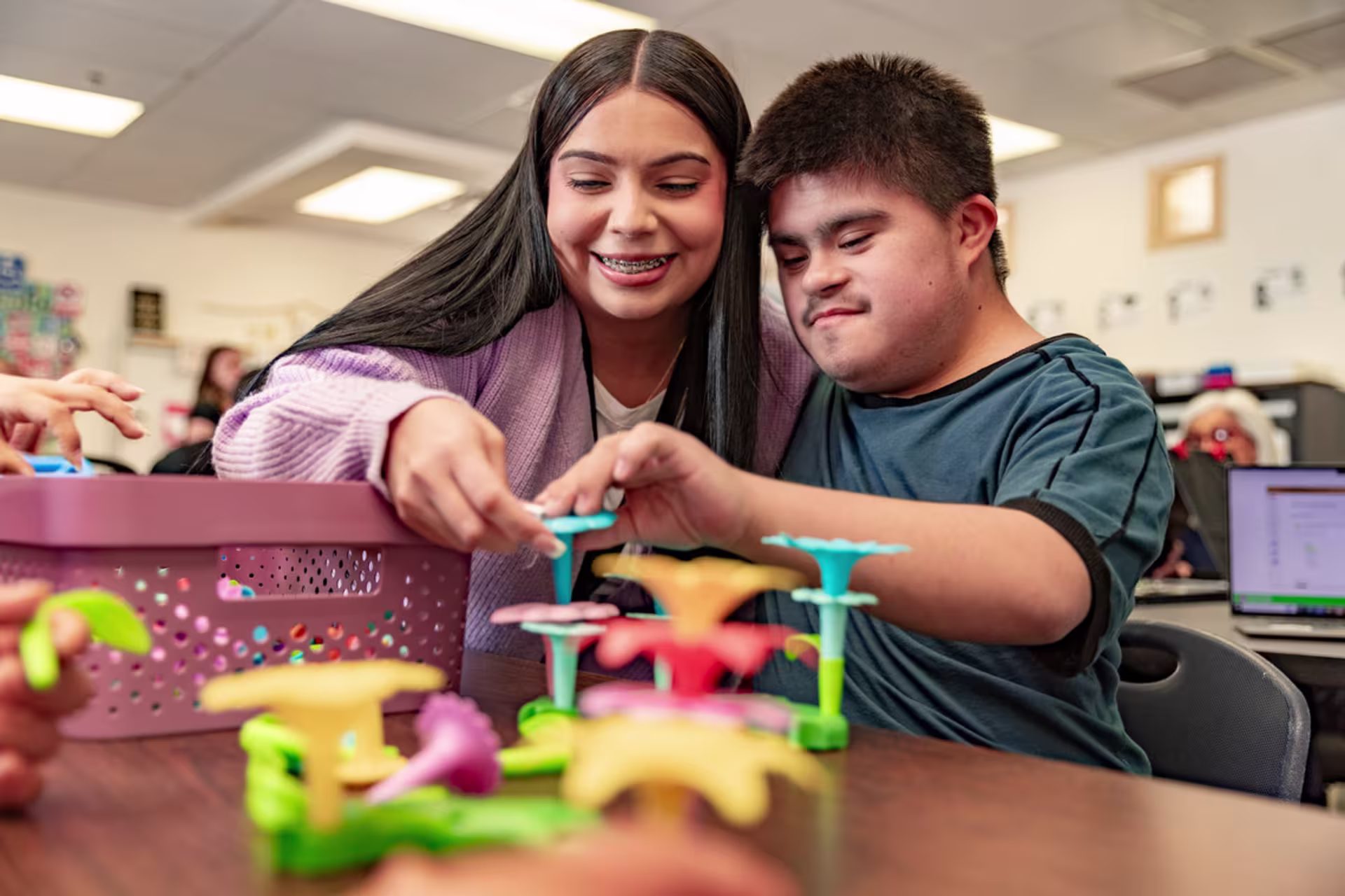 Master’s in education student working with a special needs student in a classroom setting.