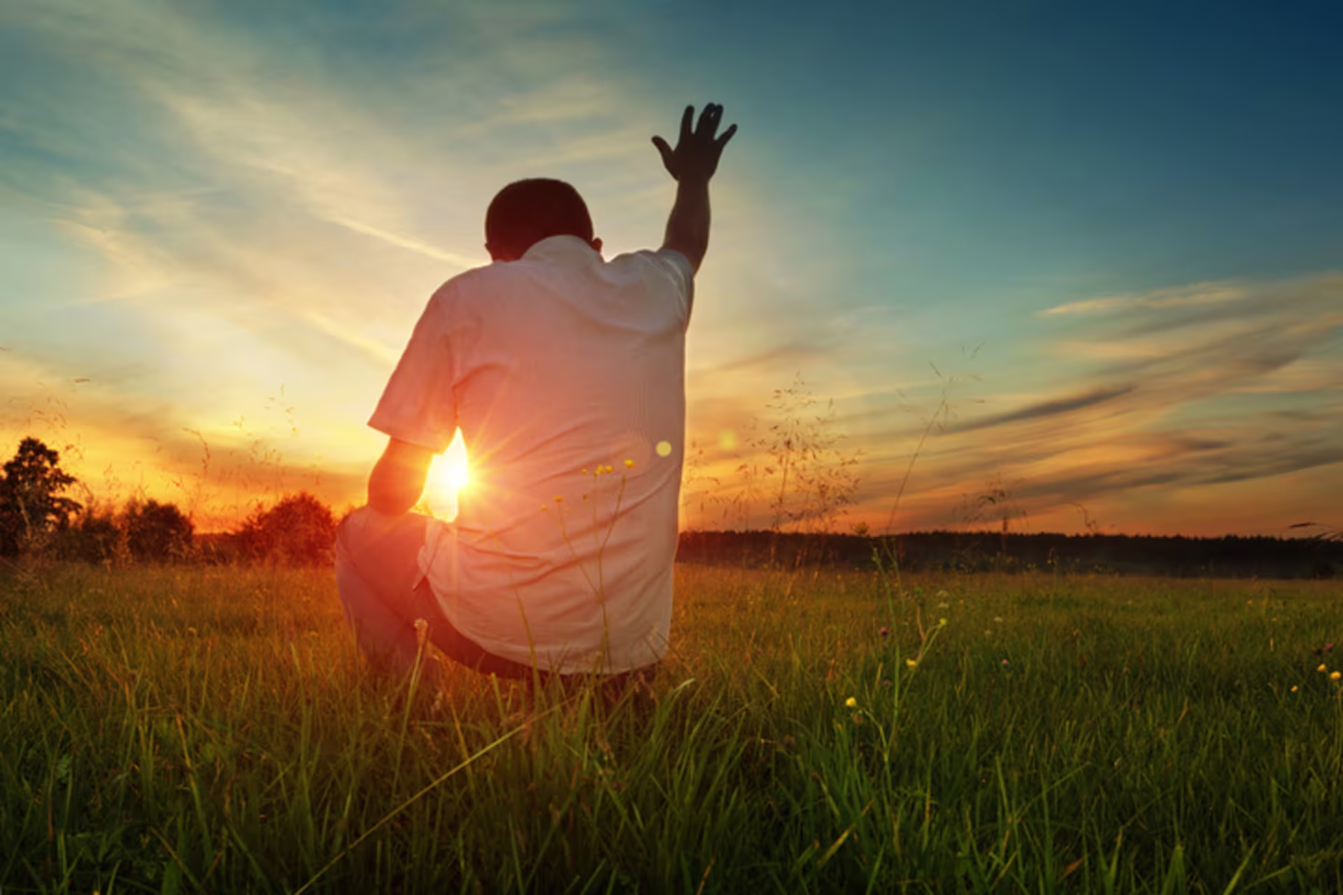 Man prays to God in grassfield