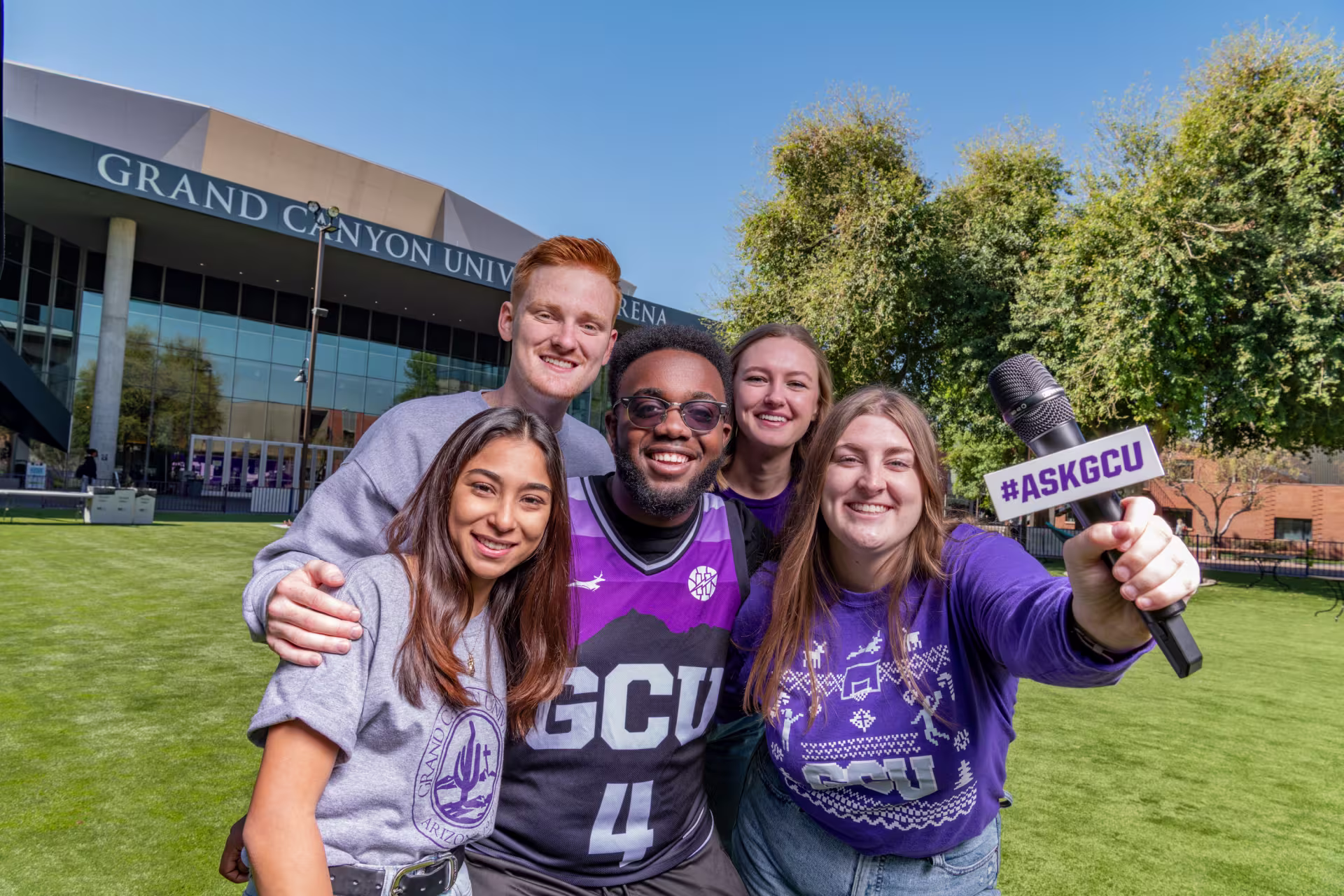 Students outside GCU arena on grass.