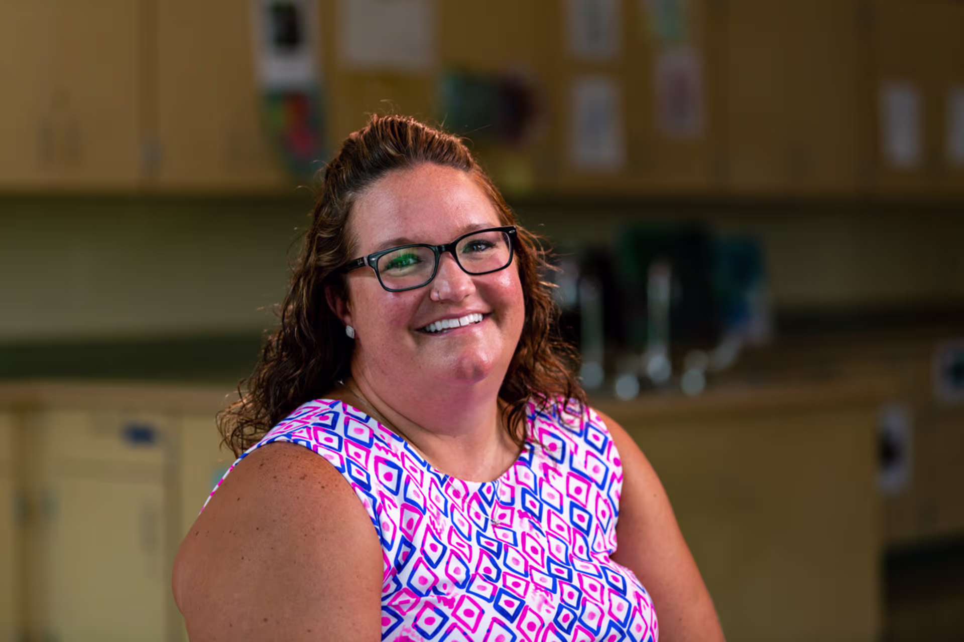 Principal smiles at camera in a classroom at an education administration event after school hours.