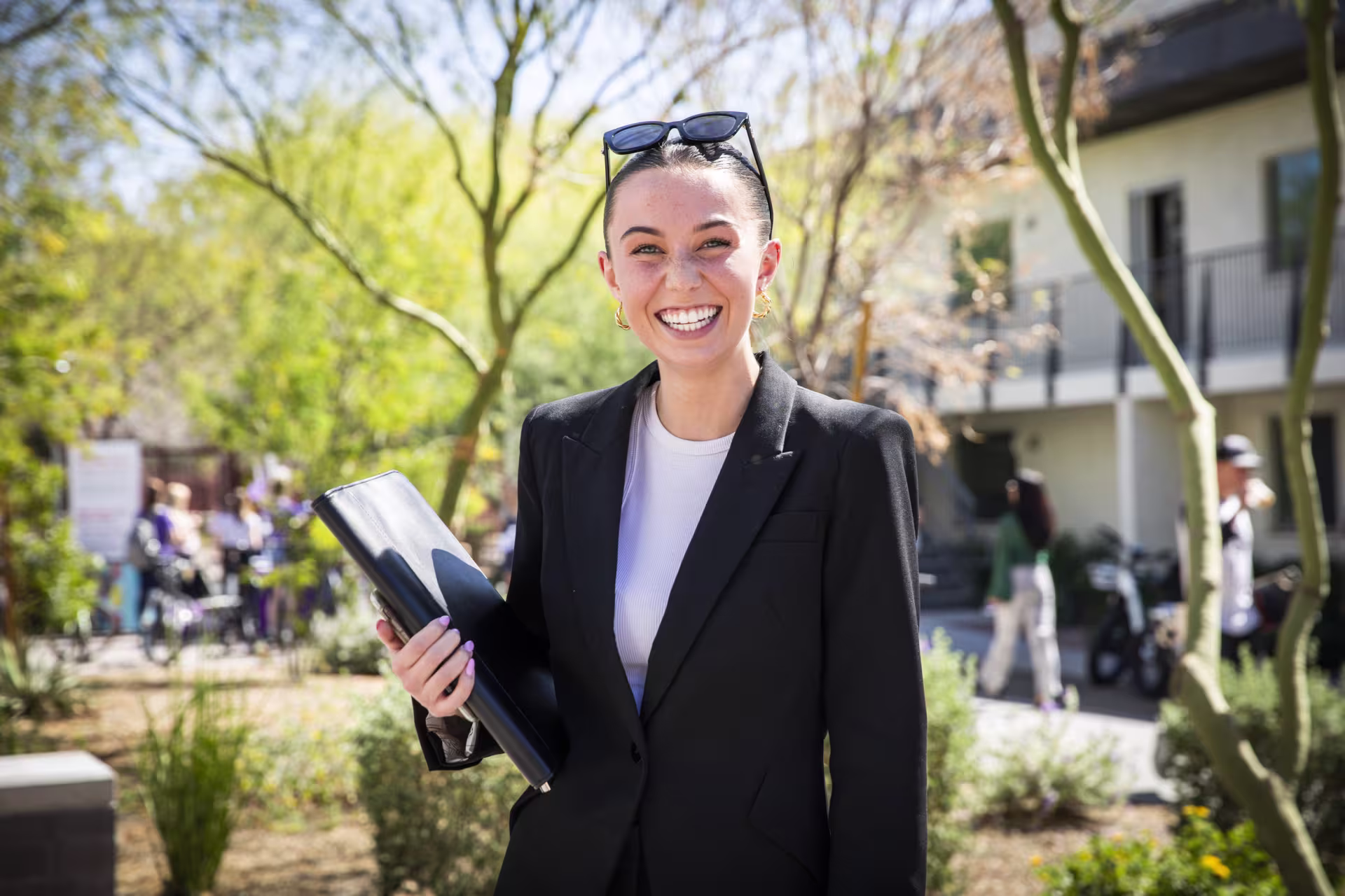 Female DBA student wearing suit jacket and smiling outside