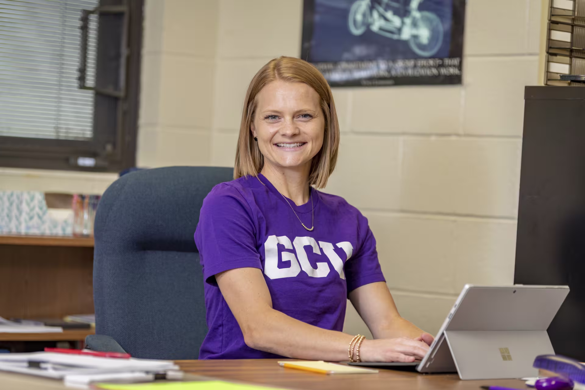 Woman at her desk on her computer ready to teach