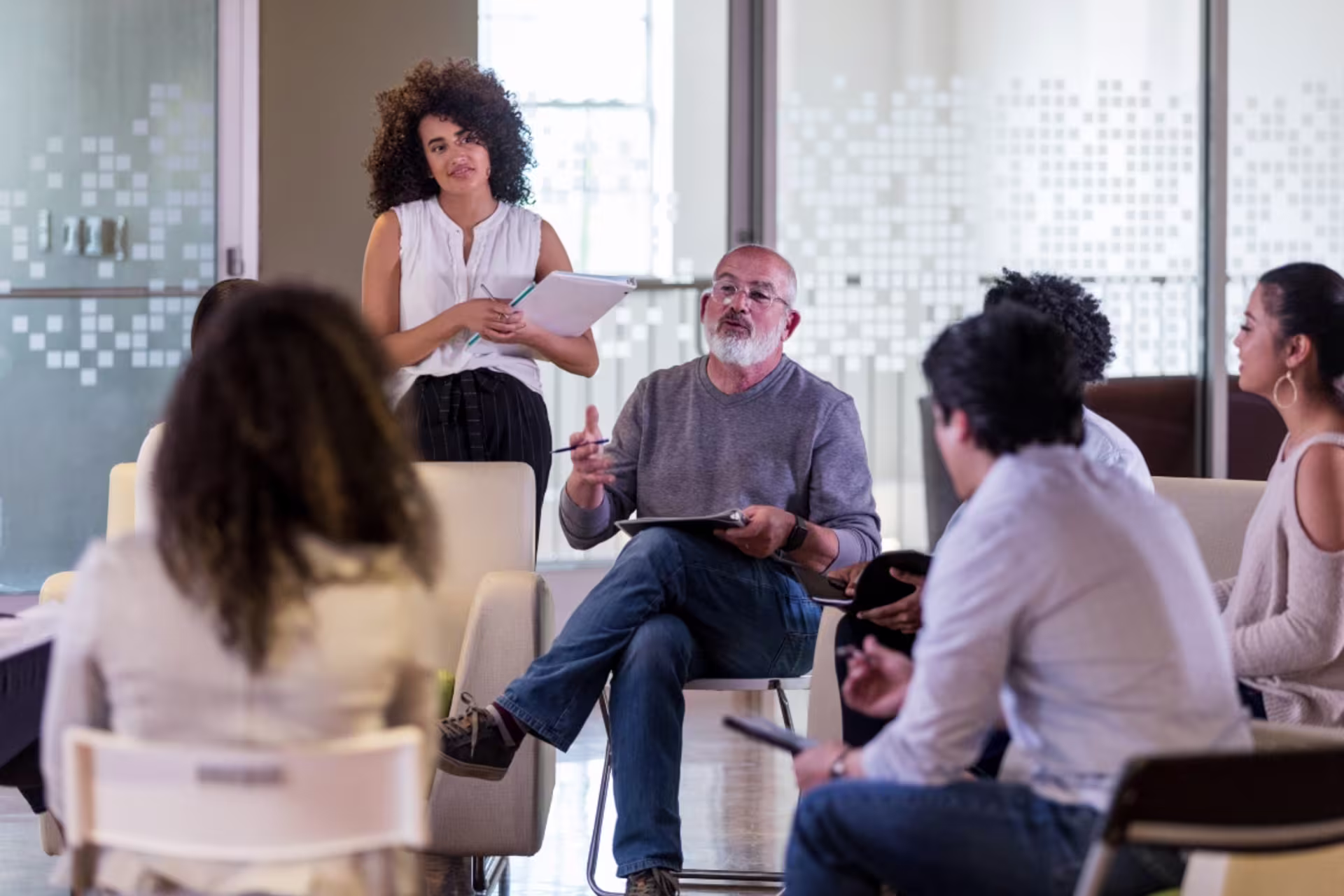 Group of students in a classroom setting discussing research concepts with a facilitator, representing cognitive and instructional learning.