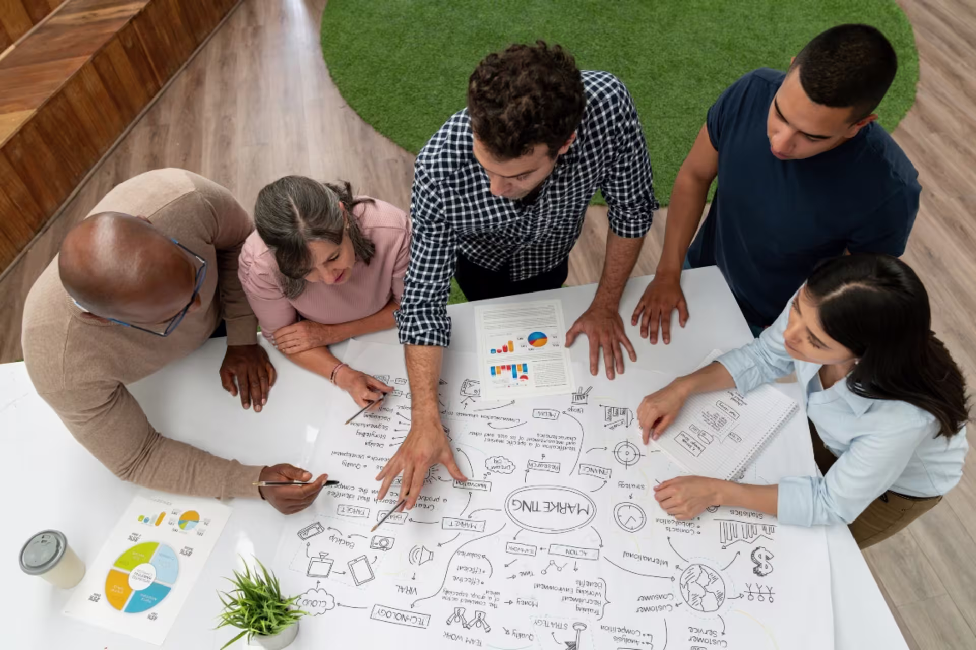 MBA in marketing students work together around a table to formulate a marketing plan.