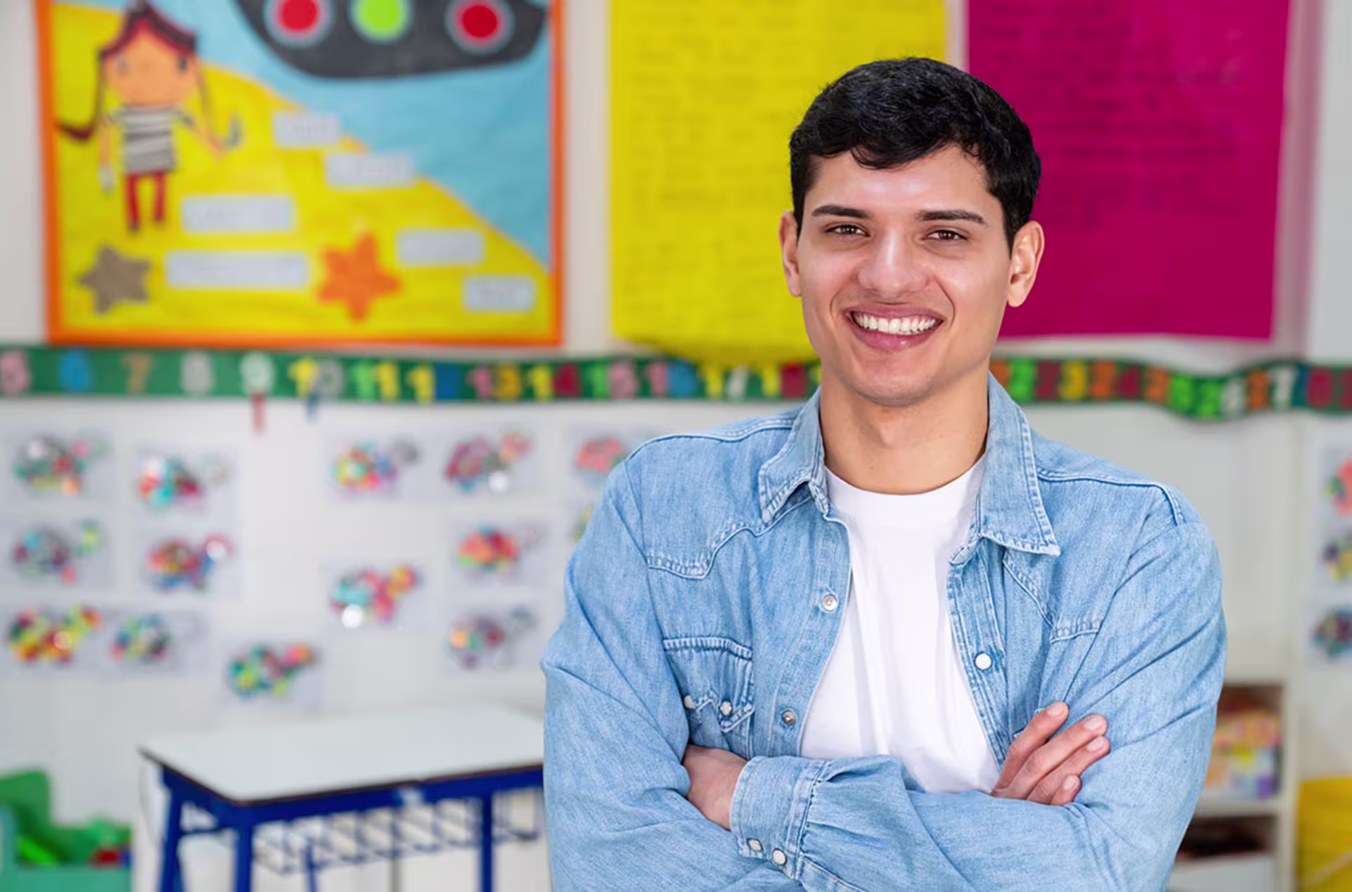 Male elementary teacher smiling in classroom.