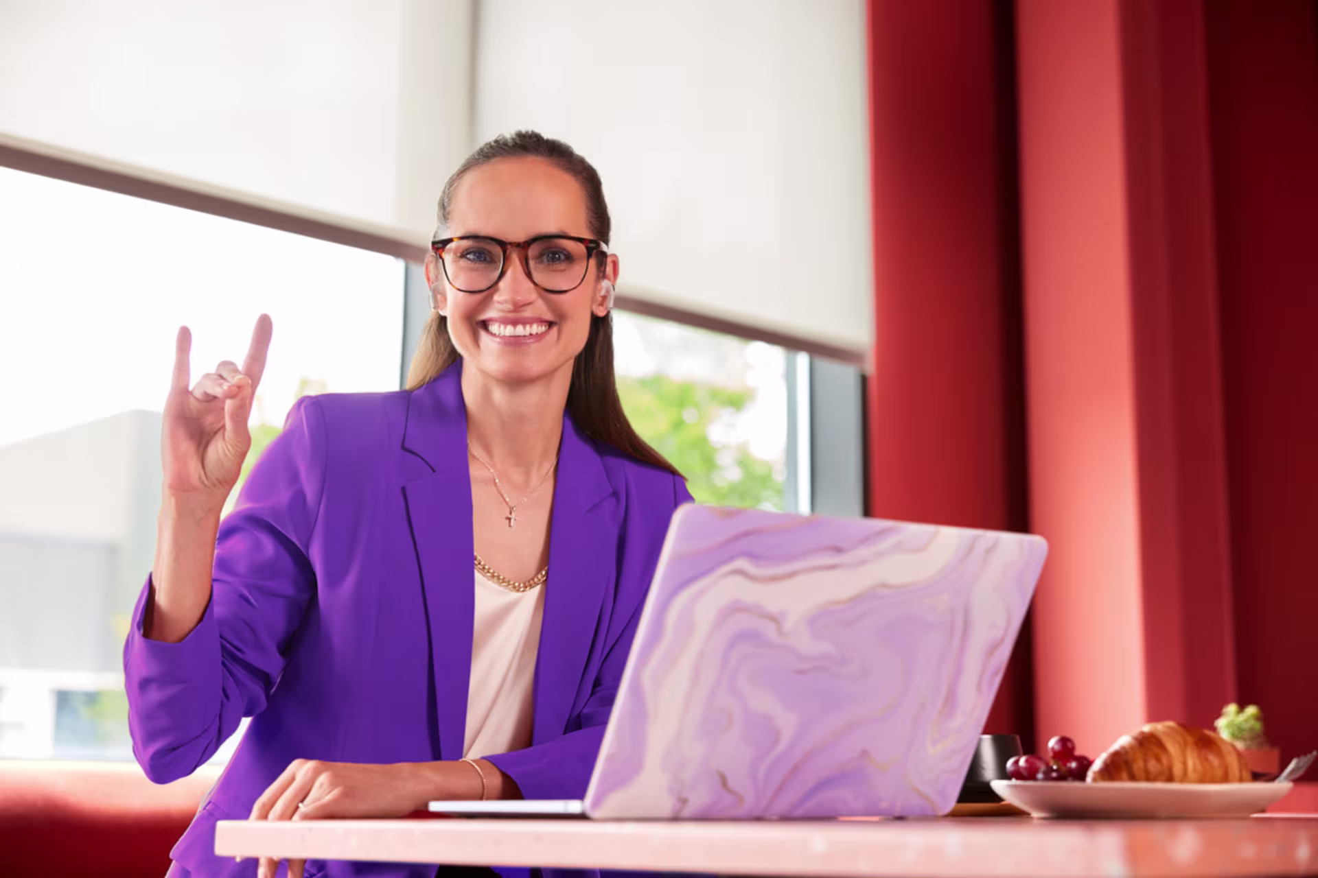 A business analytics employee gives the Lopes Up sign after earning an MSBA degree from GCU.