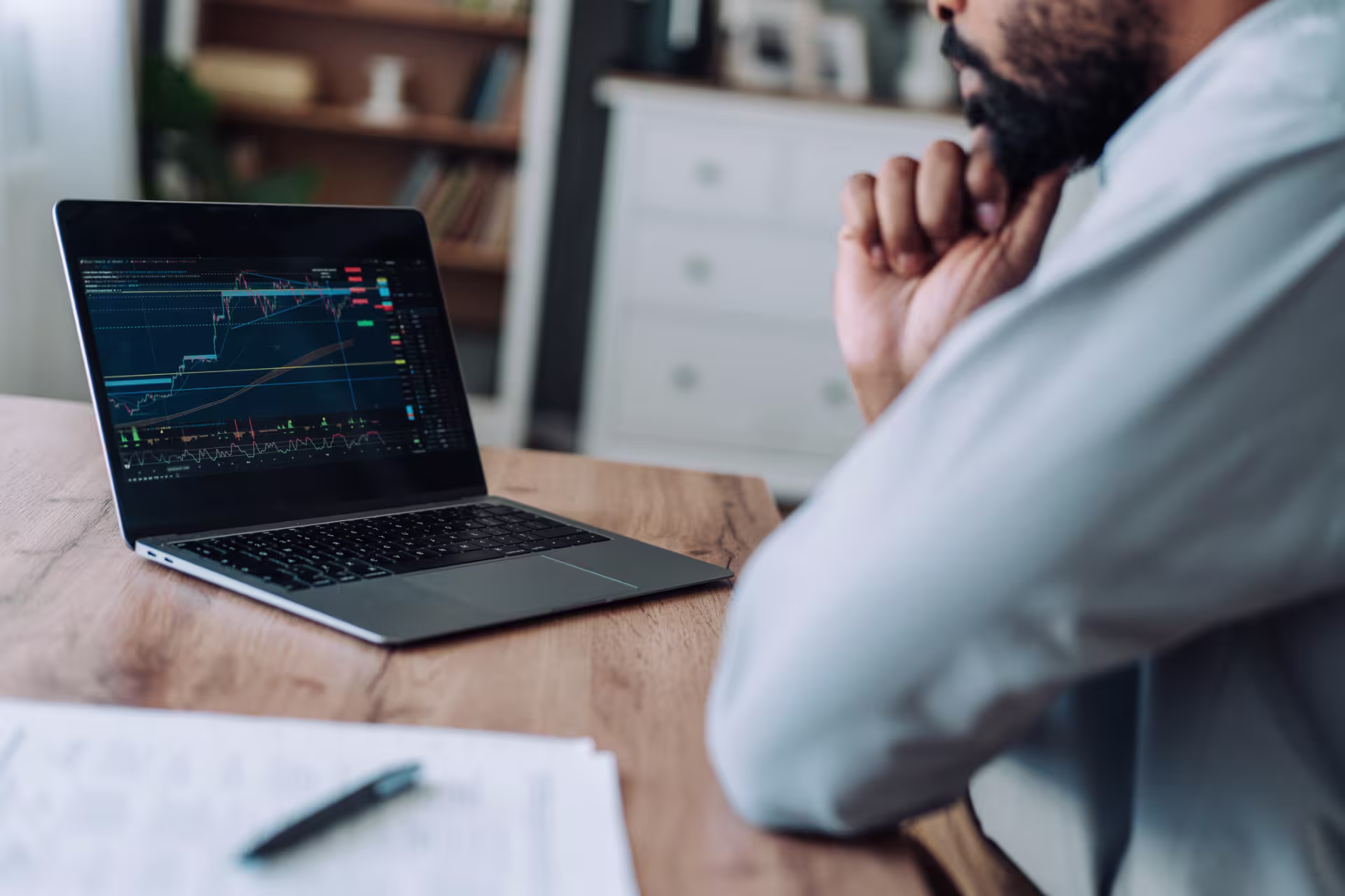 Financial analyst reviewing stock charts and market trends on a laptop.