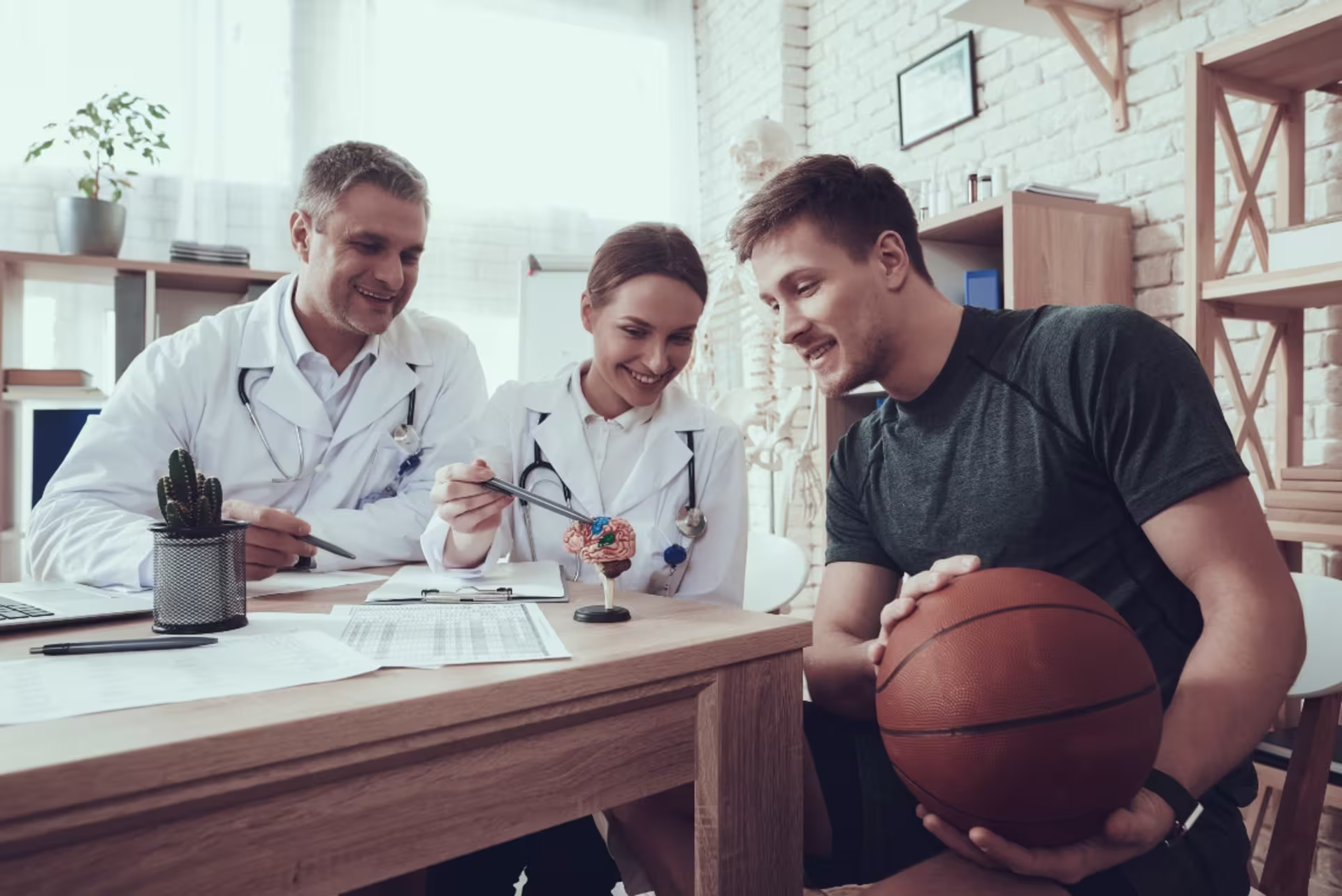 Athlete meeting with two performance and sport psychologists for mental training in an office setting.