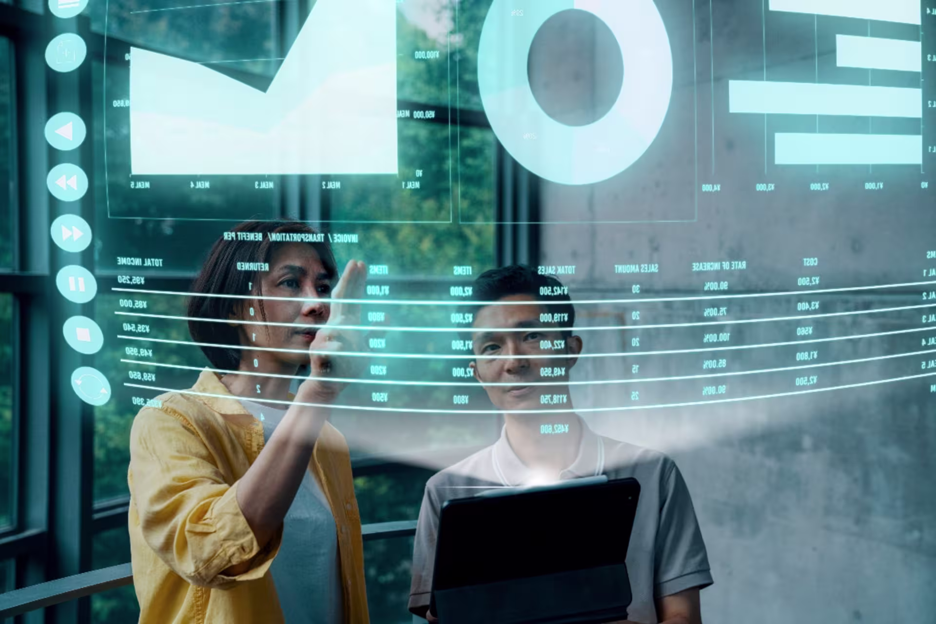 Two people analyzing digital data visualizations on a large transparent screen in a modern tech environment.
