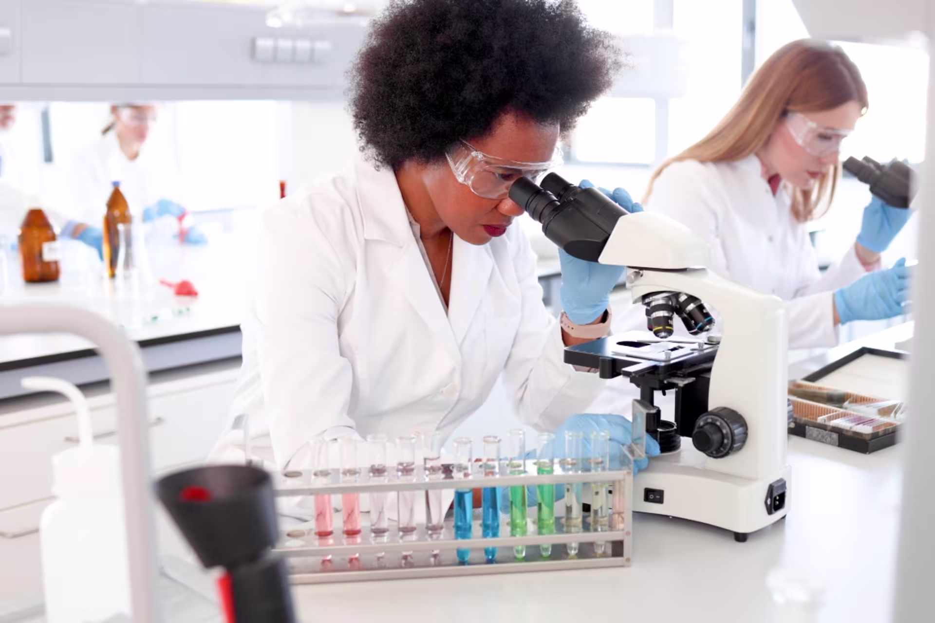Forensic science students examining samples under microscopes in a laboratory.