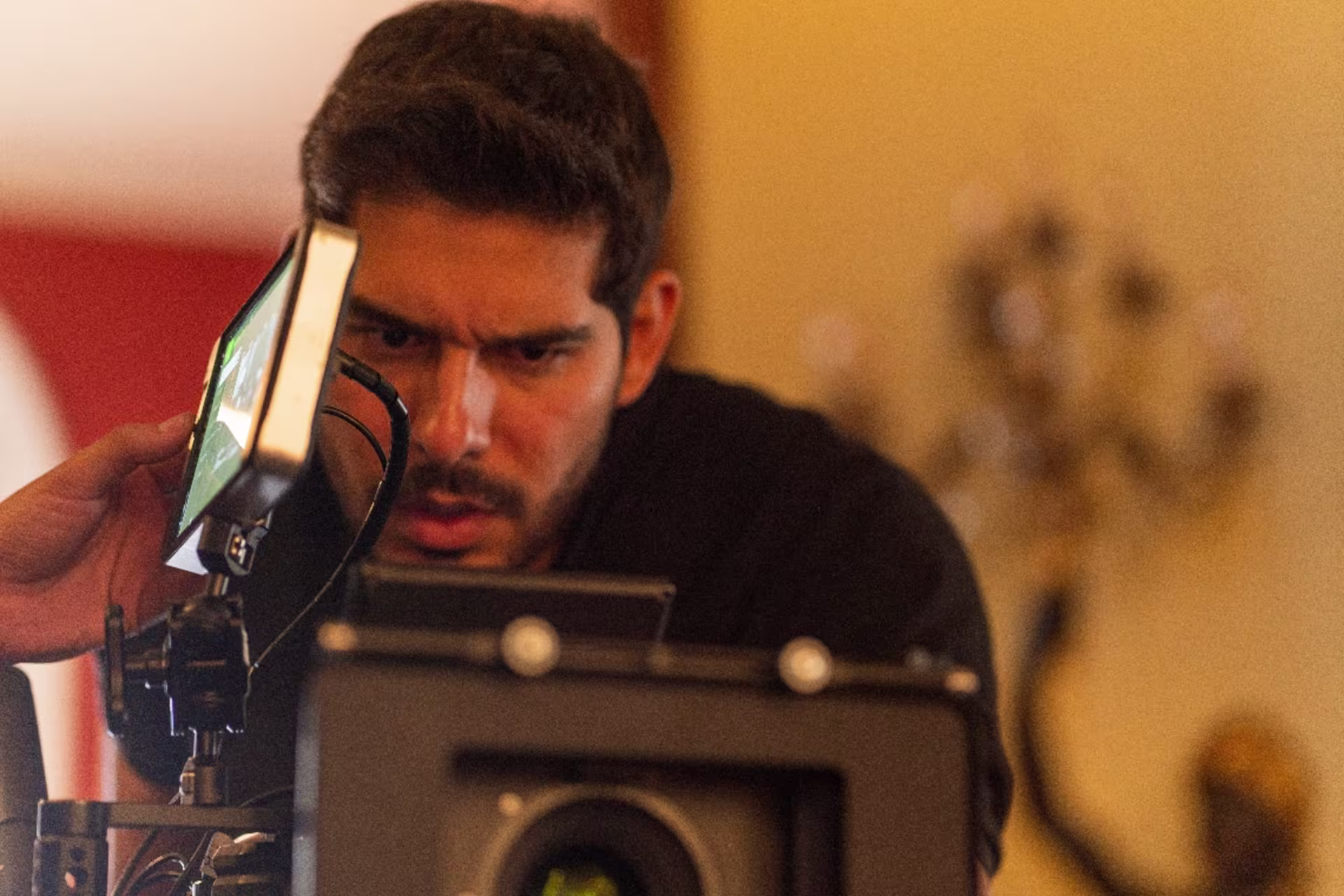 Camera operator adjusting a professional film camera during a video production setup.