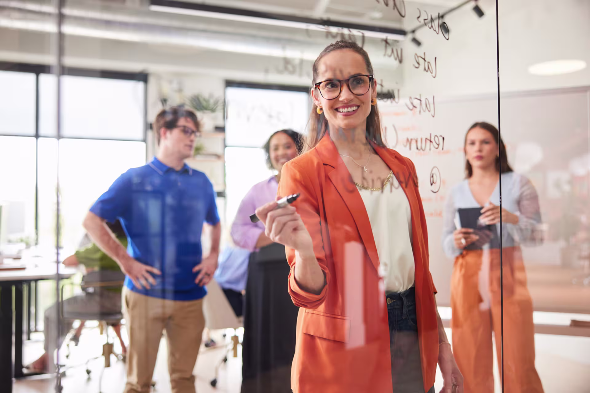 A group of GCU business administration students planning strategy in modern office meeting.