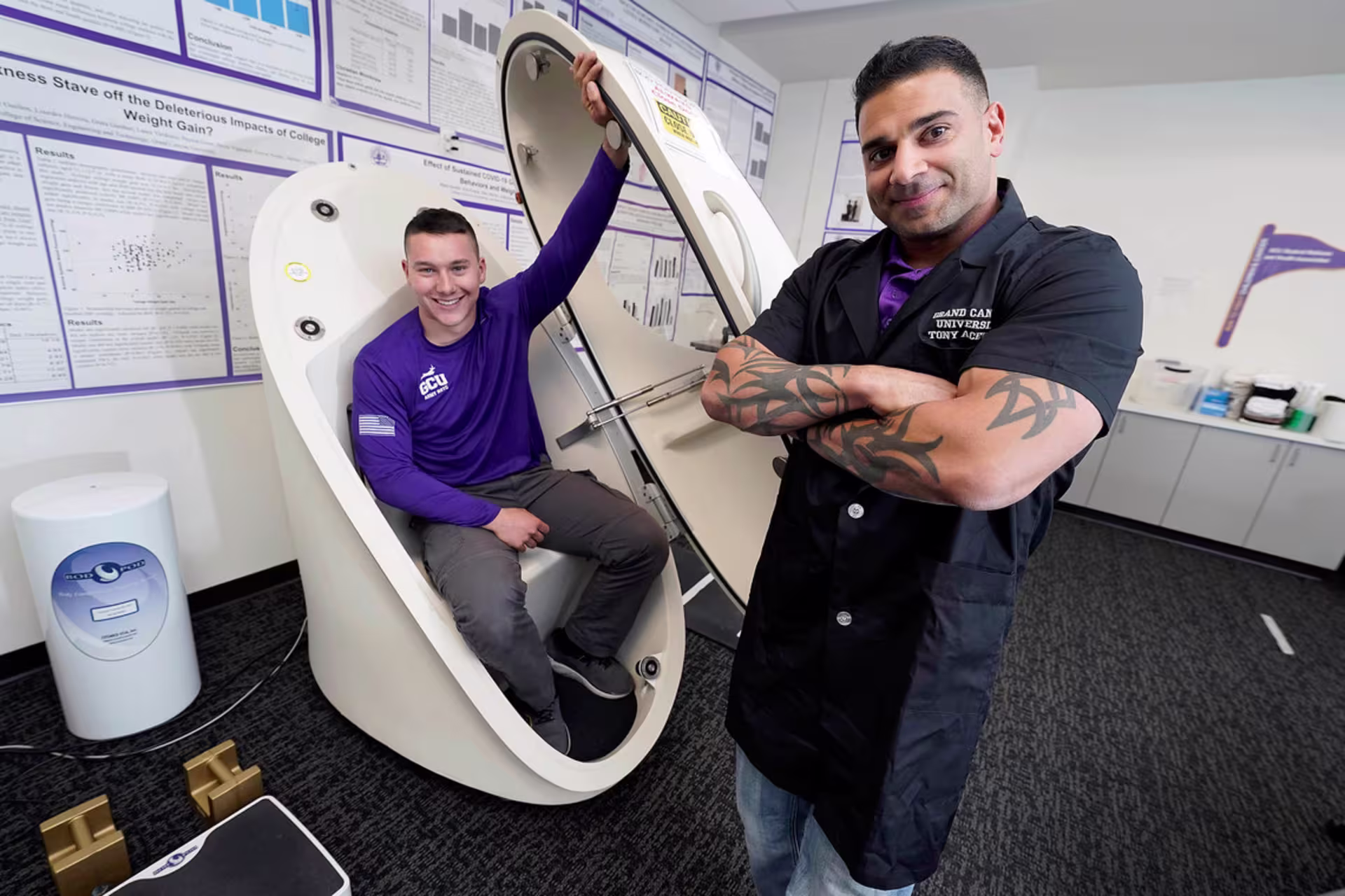 Male GCU exercise science students use equipment in a classroom setting.