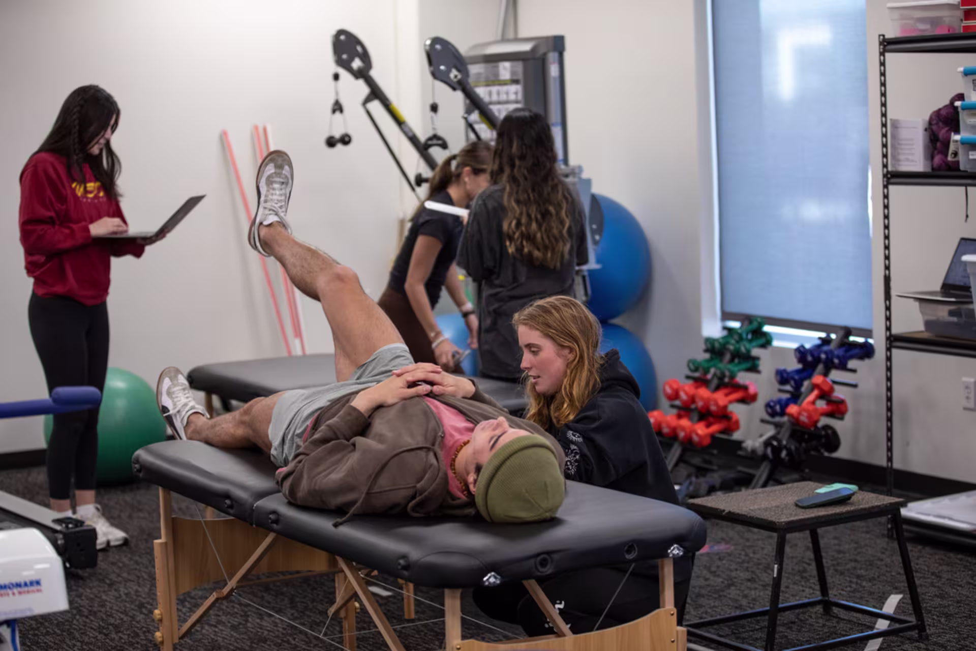 GCU exercise science students work together on a group assignment, testing personal flexibility.