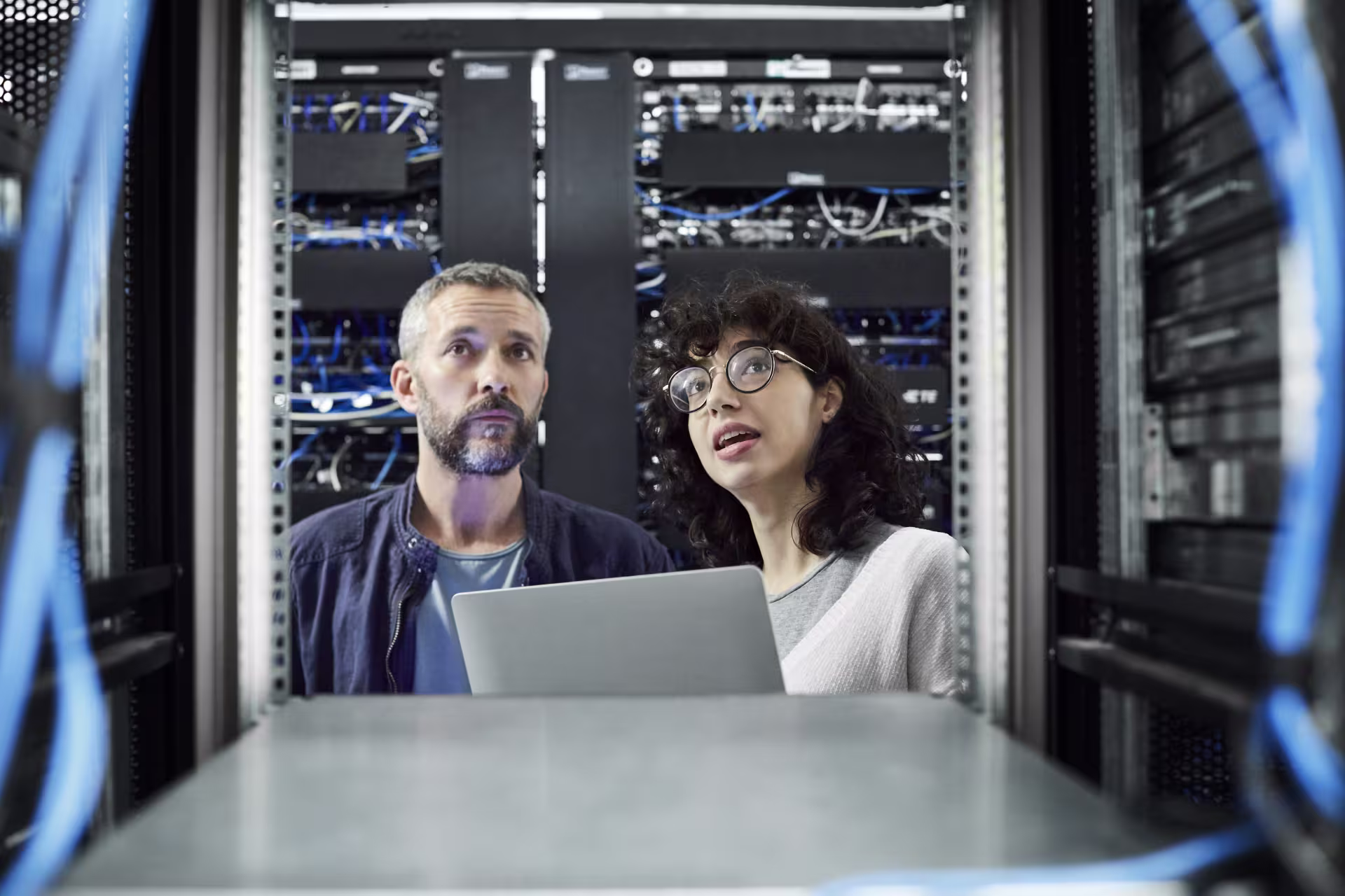 IT professionals monitoring server infrastructure and network equipment in a secure data center.