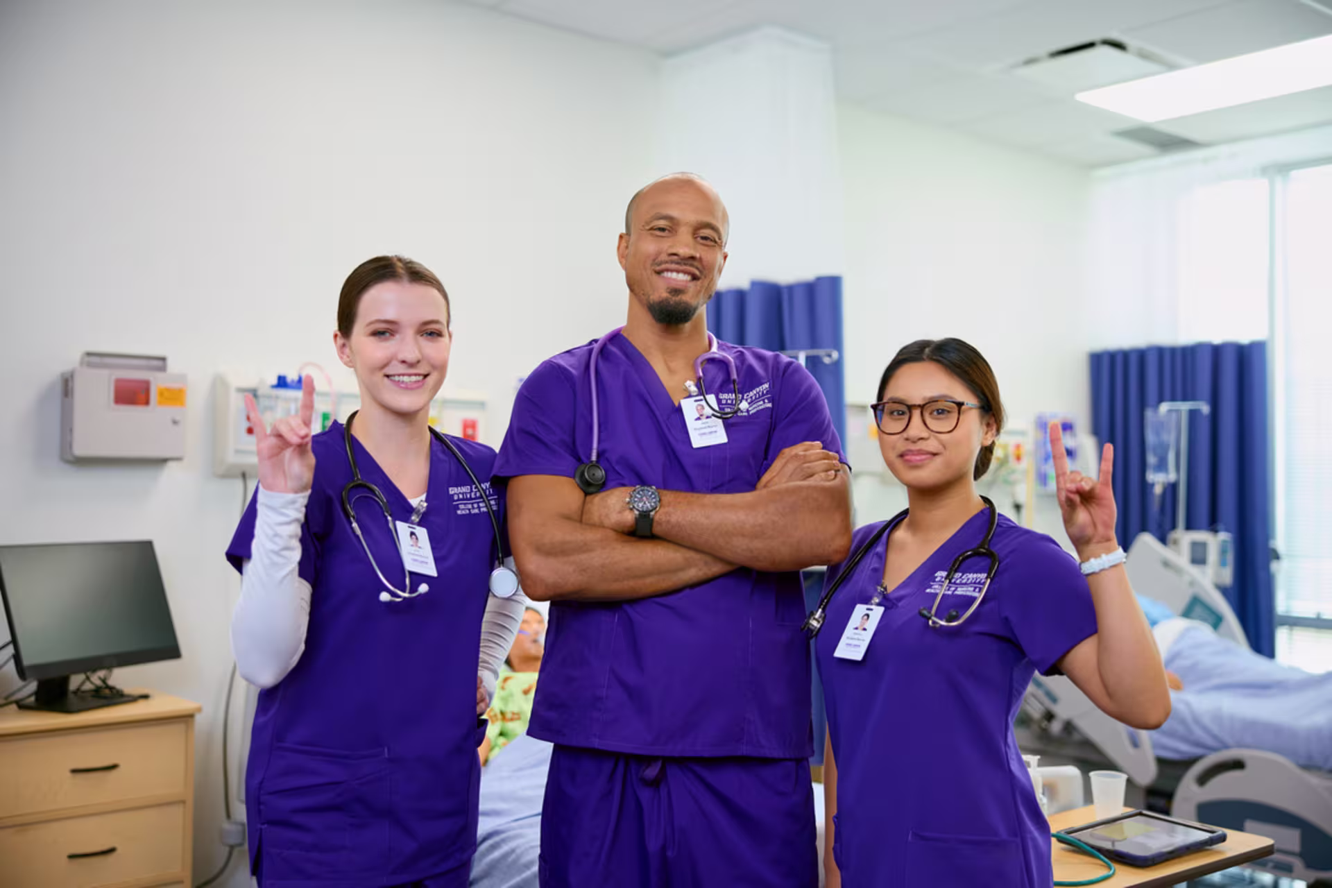 Nursing students pose together in a clinical training environment.