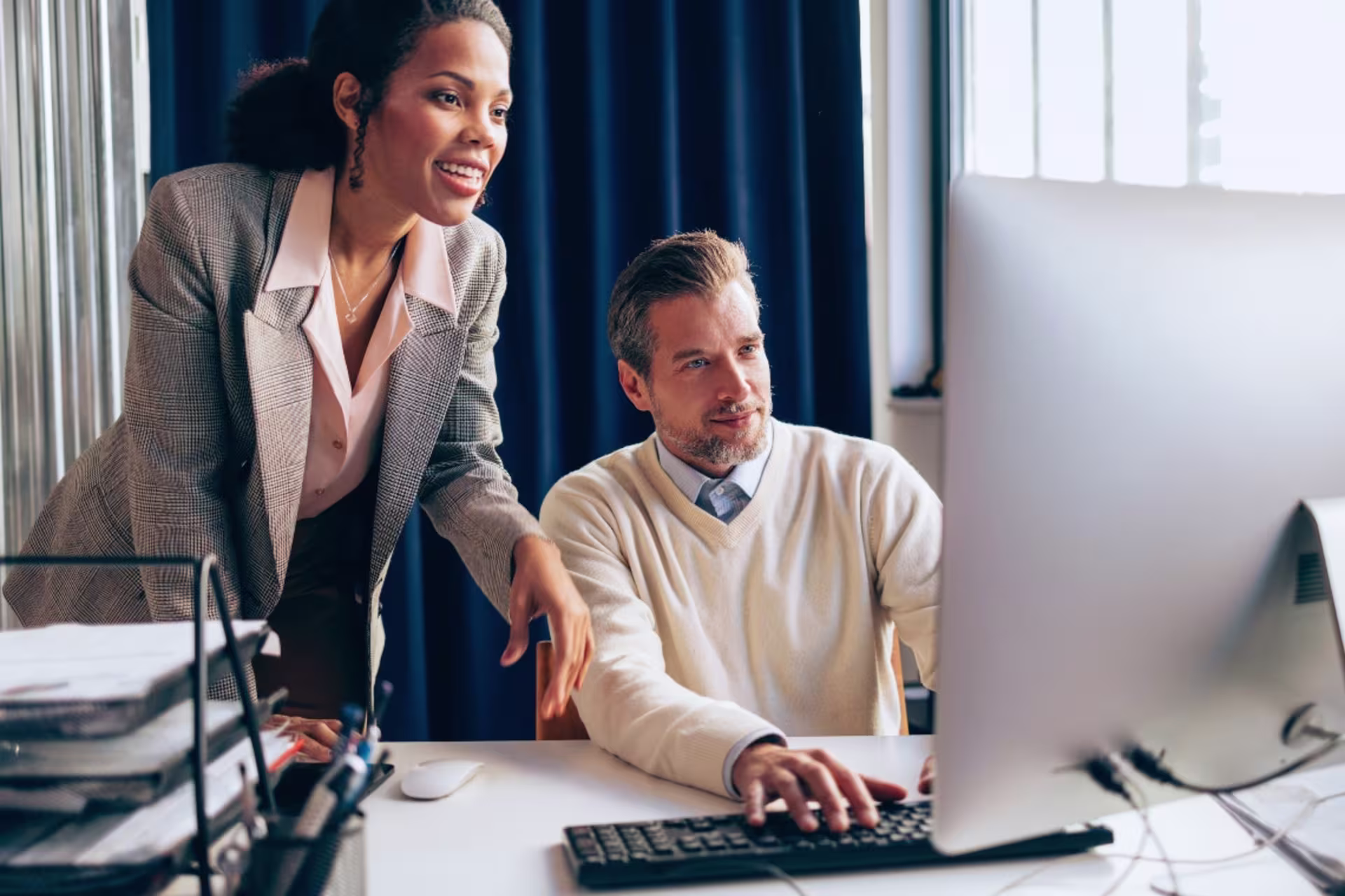 A social media manager reviews digital content strategy with a colleague.