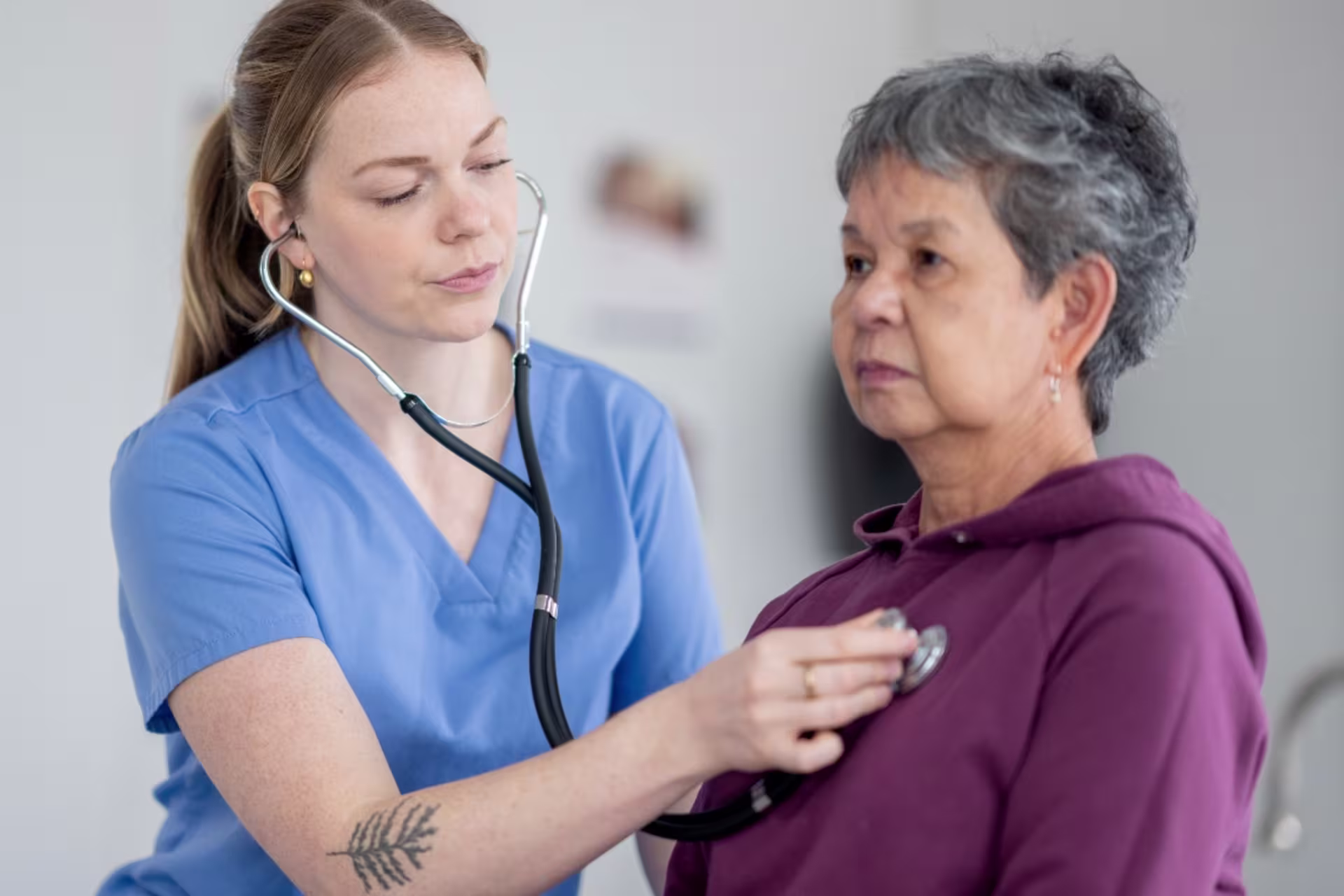 An acute care gerontology nurse assesses an older adult patient during an exam.