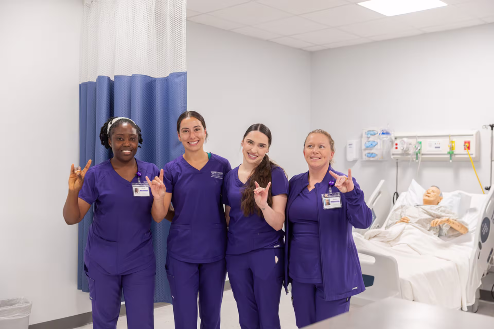 Nursing degree students practice clinical skills in a patient simulation lab.