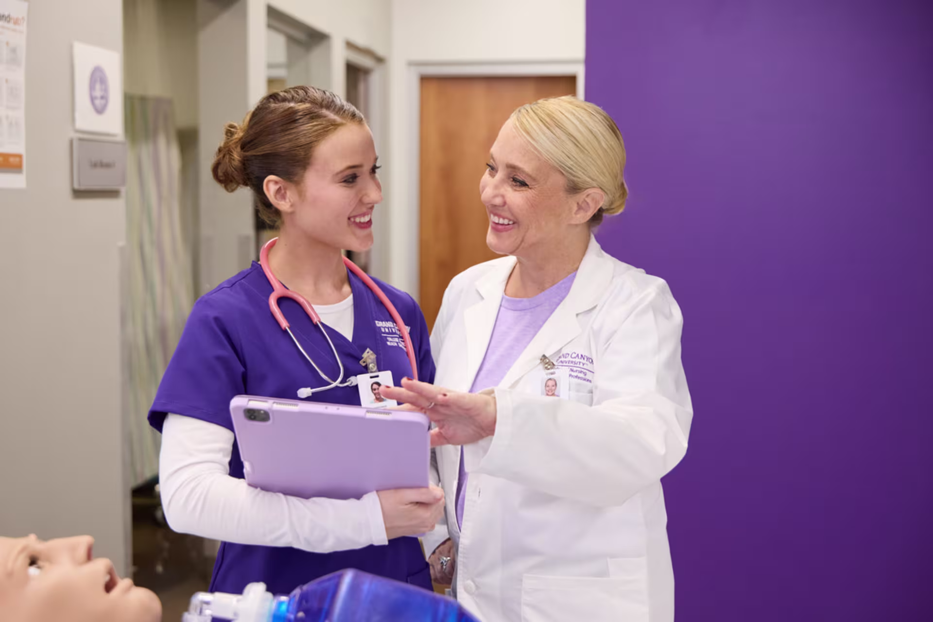 A nurse and doctor review patient information on a tablet together.