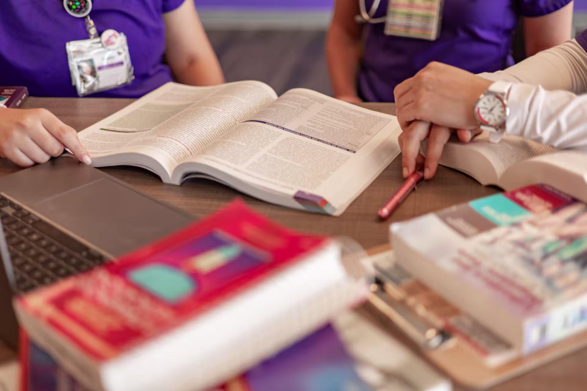 A nursing student reviews a textbook during a study session.