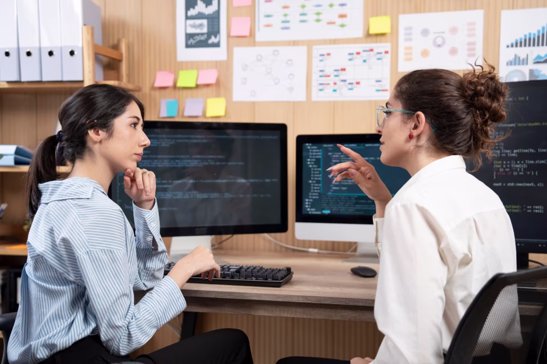 Data science graduate students collaborate on programming and analytics projects using coding software.