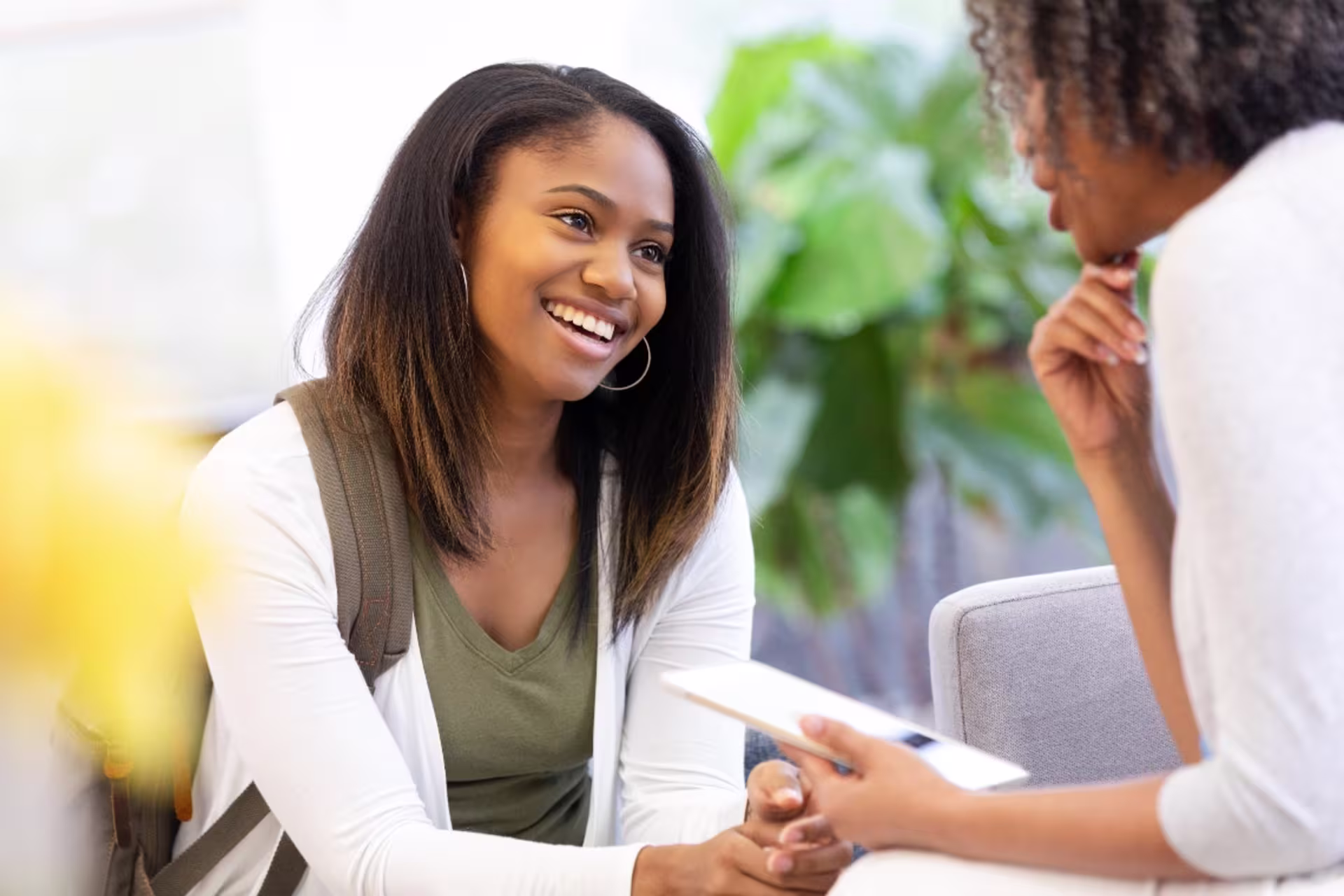 A school counselor meets with a student and engages in a supportive conversation.