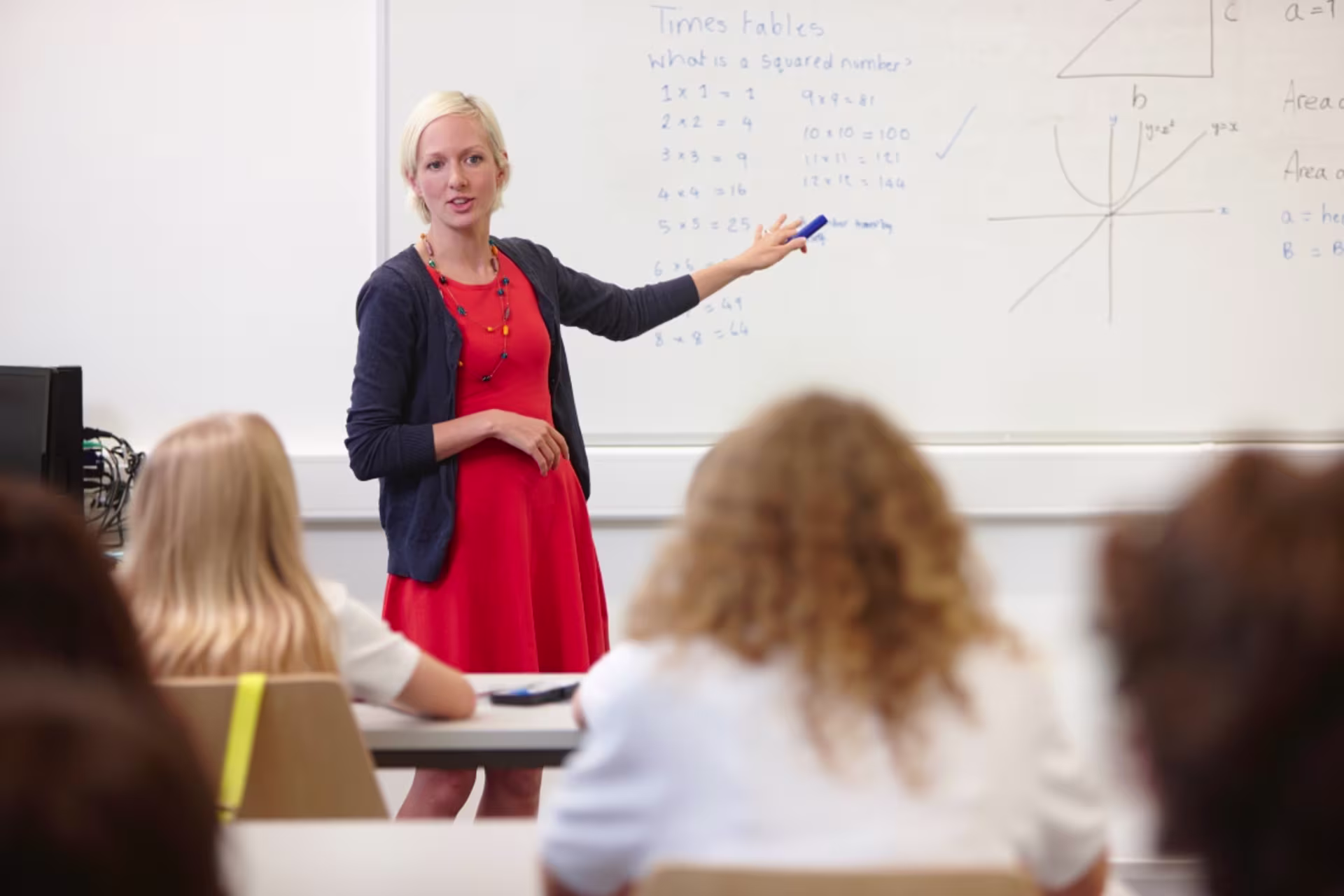A secondary school mathematics teacher explains algebra concepts to students.
