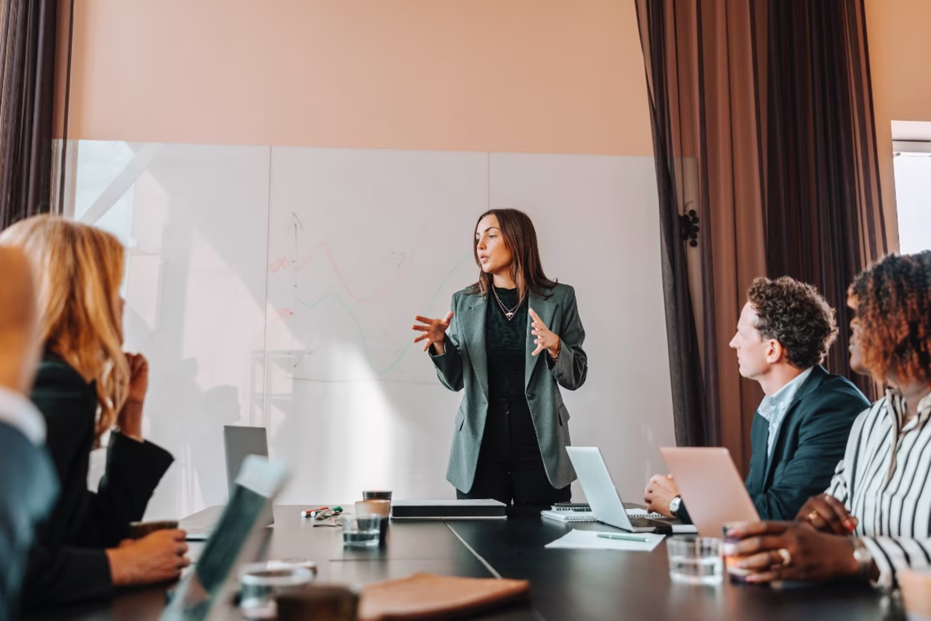 A corporate leadership professional presents strategy during a team meeting.