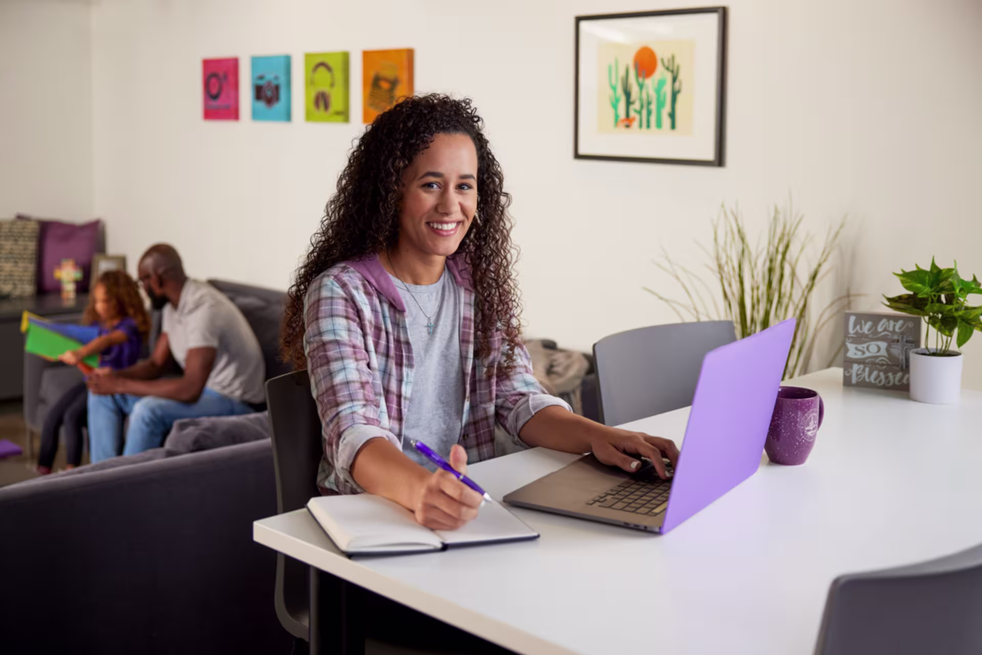 An online organizational leadership student takes notes while attending a virtual class from home.