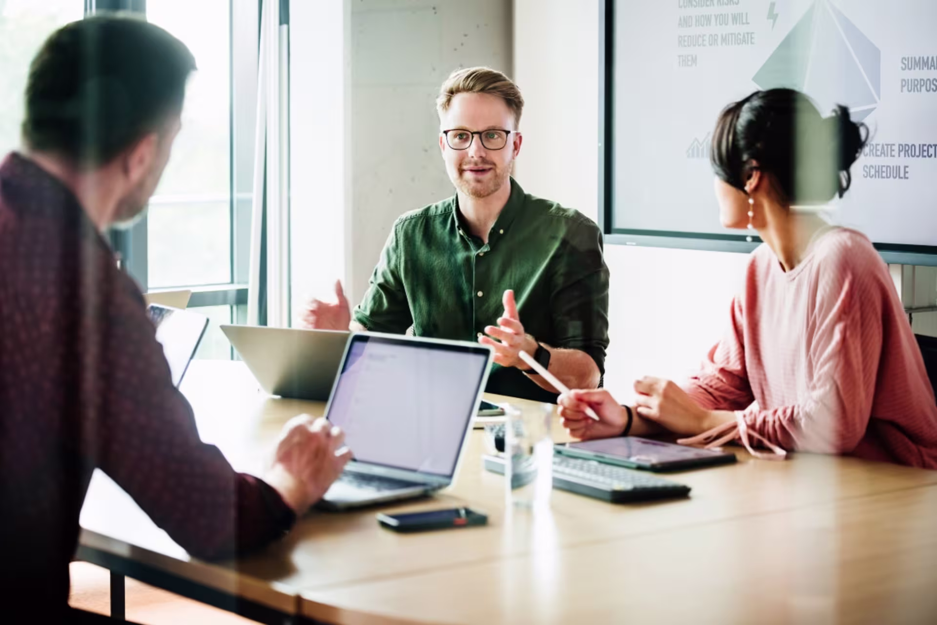 A communications professional leads a team discussion during a workplace meeting.