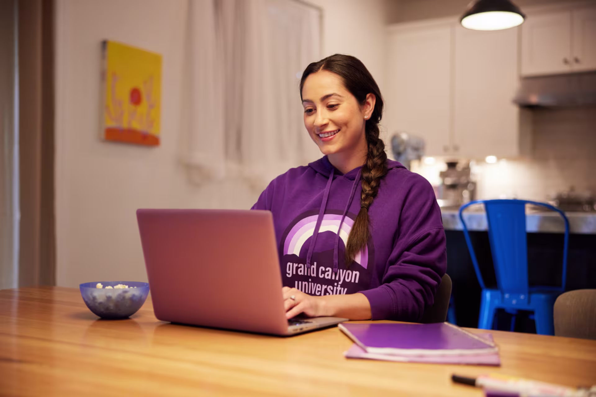 A female language degree student studies on a laptop at home.