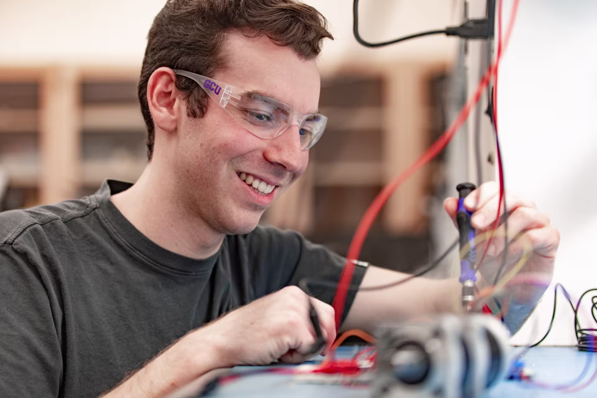 Male mechanical engineer testing electrical components in a lab.